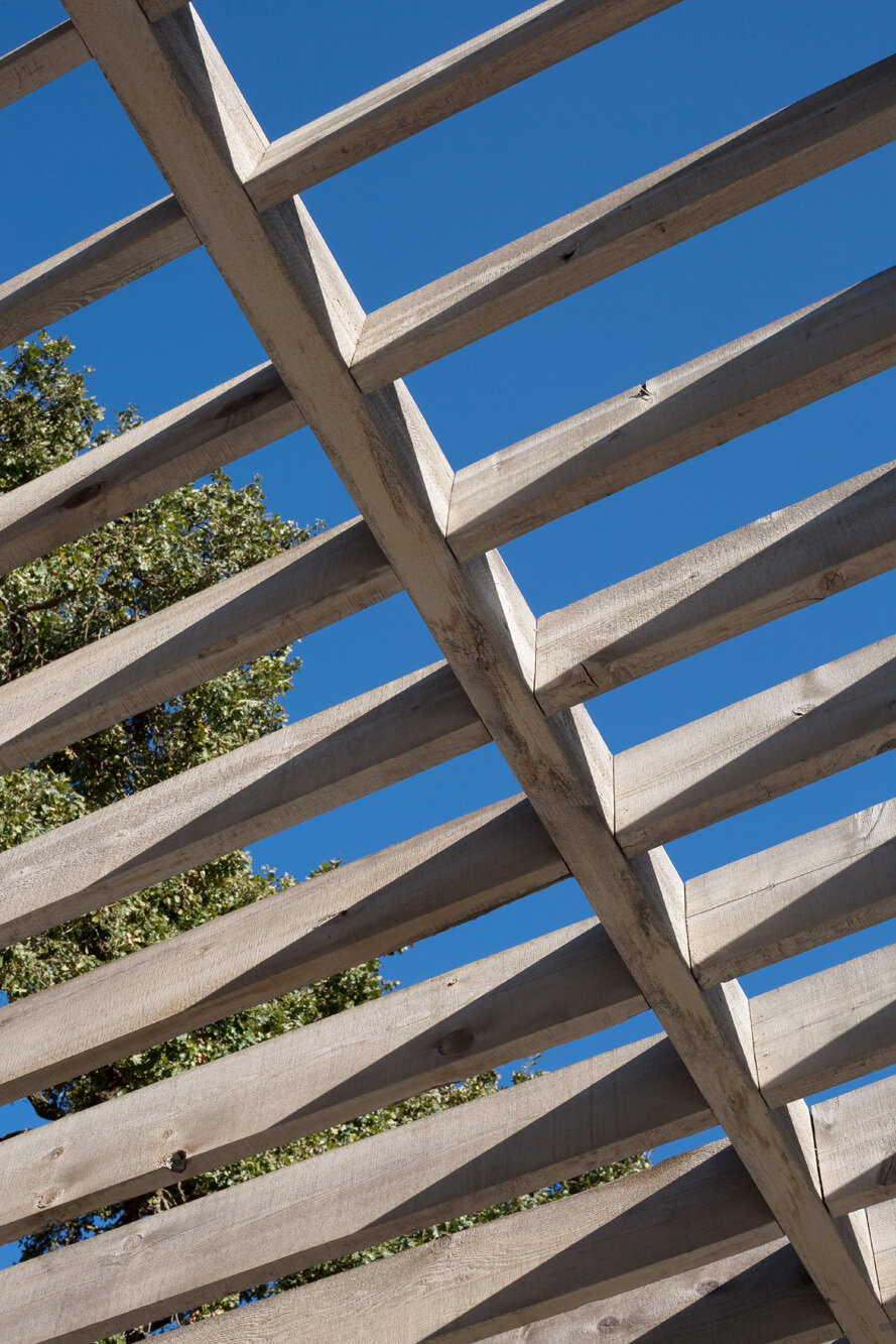 Large sliding doors connect the living room to a semi covered terrace with an outdoor kitchen and open views.