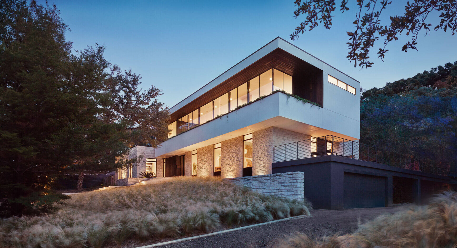 A 1950s Austin ranch house transformed with a cantilevered second storey, glass walls and a modern update that still respects the original limestone structure.