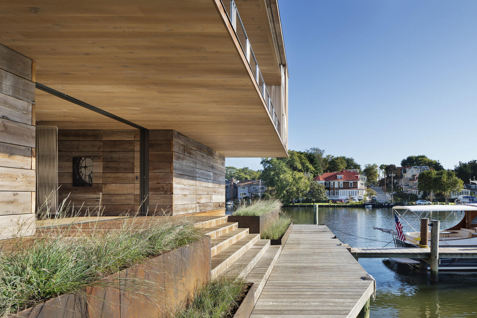 Cantilevered decks, deep overhangs, and layered Ipe screens define the upper level of this modern Chesapeake Bay home.