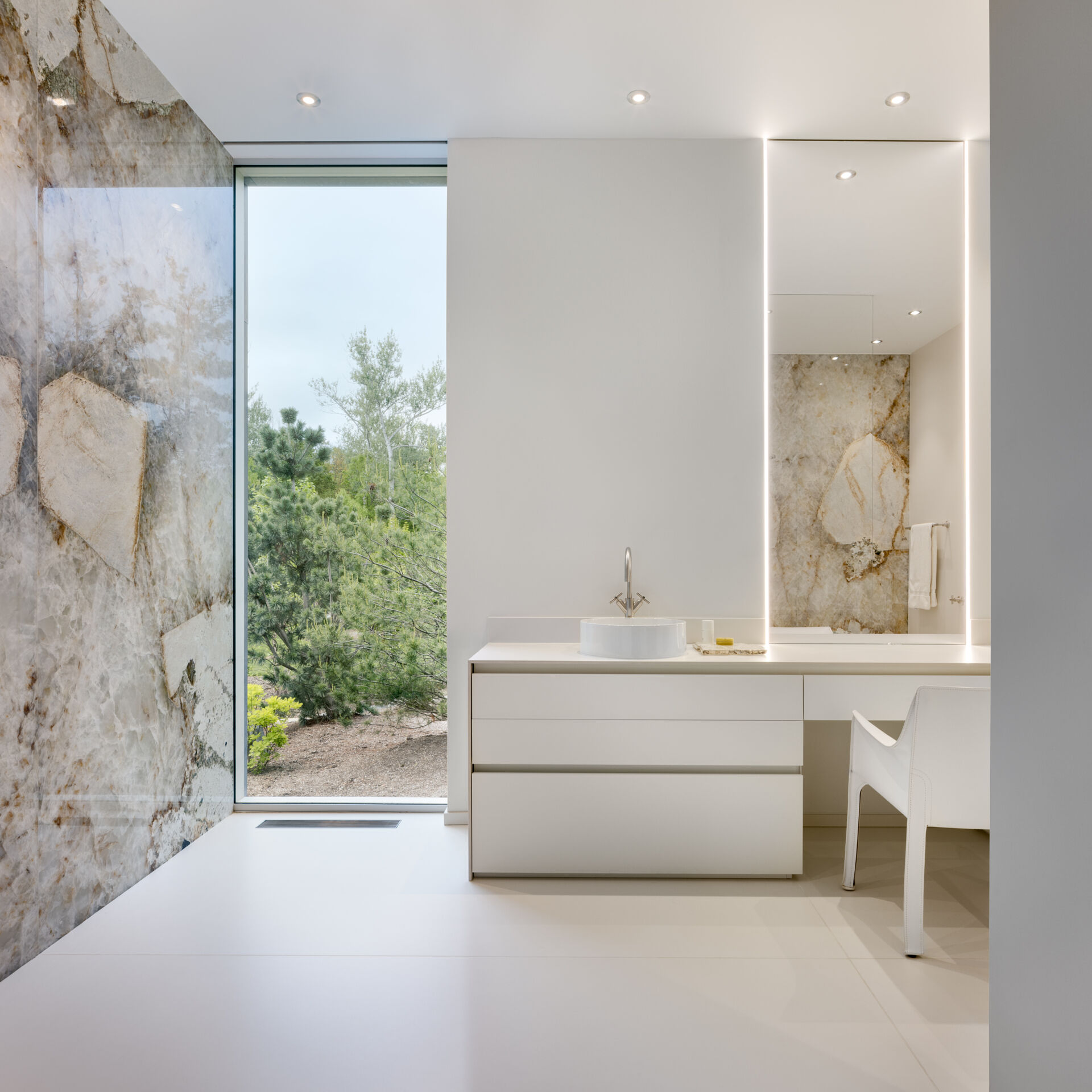 Baño blanco moderno con detalles en piedra.