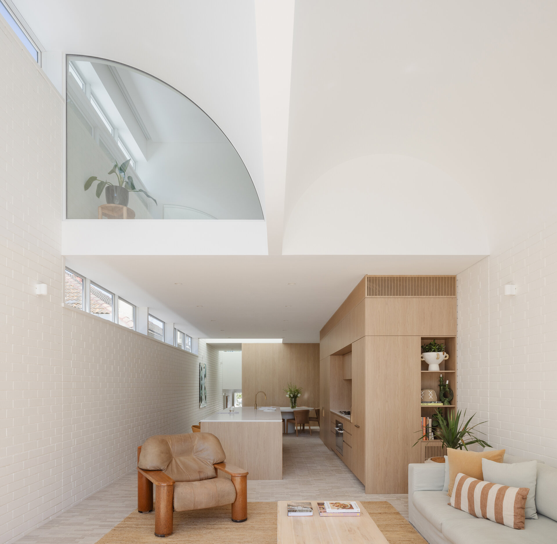 The kitchen sits within the open ground floor plan, defined by integrated joinery. It forms part of a shared zone with the dining and living spaces.