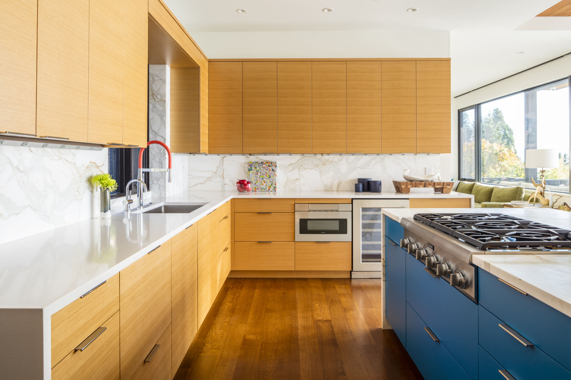 A colorful, contrasting island anchors the open kitchen while keeping it connected to living and dining spaces.