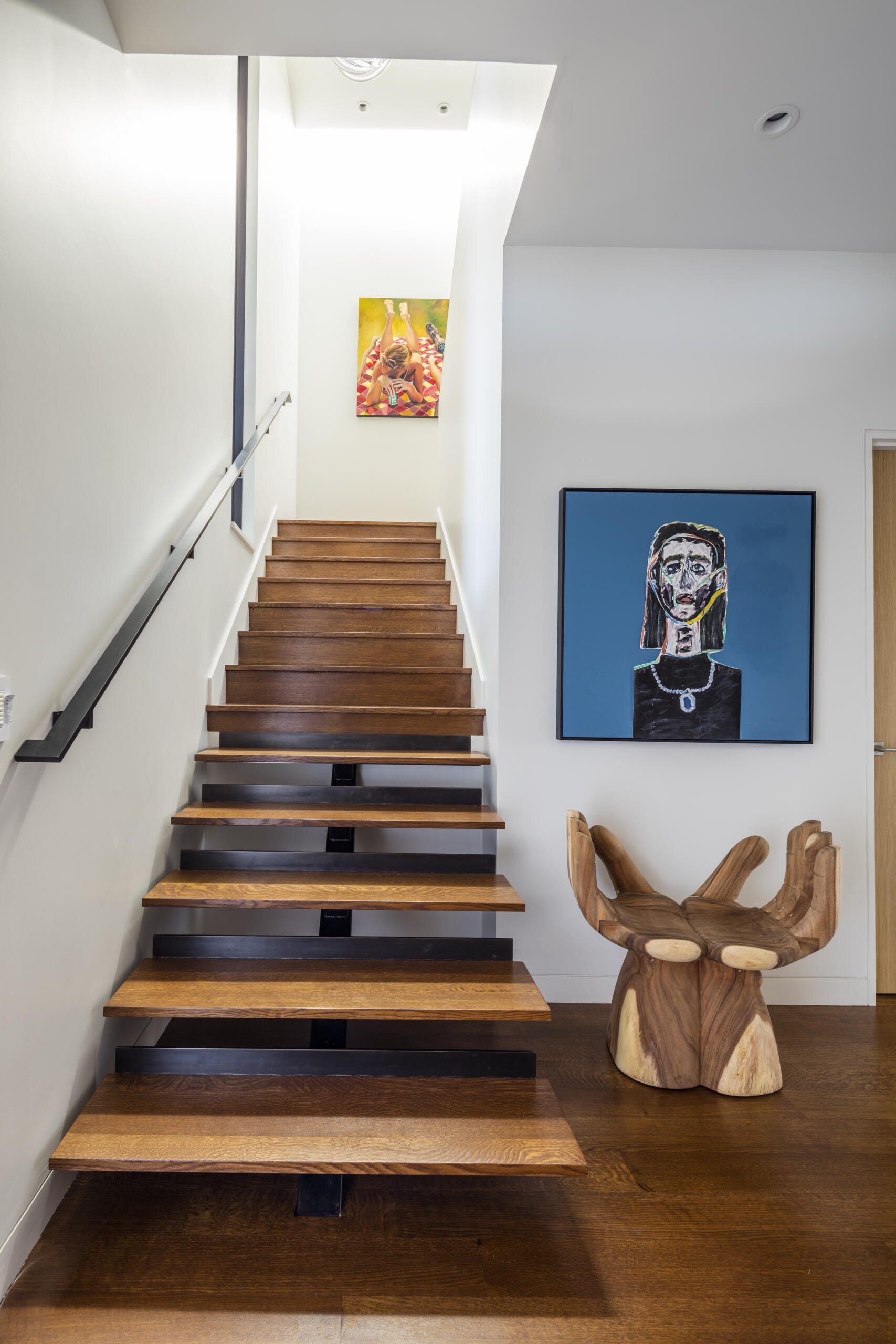 An open-riser stair with wood treads connects levels while maintaining visual openness.