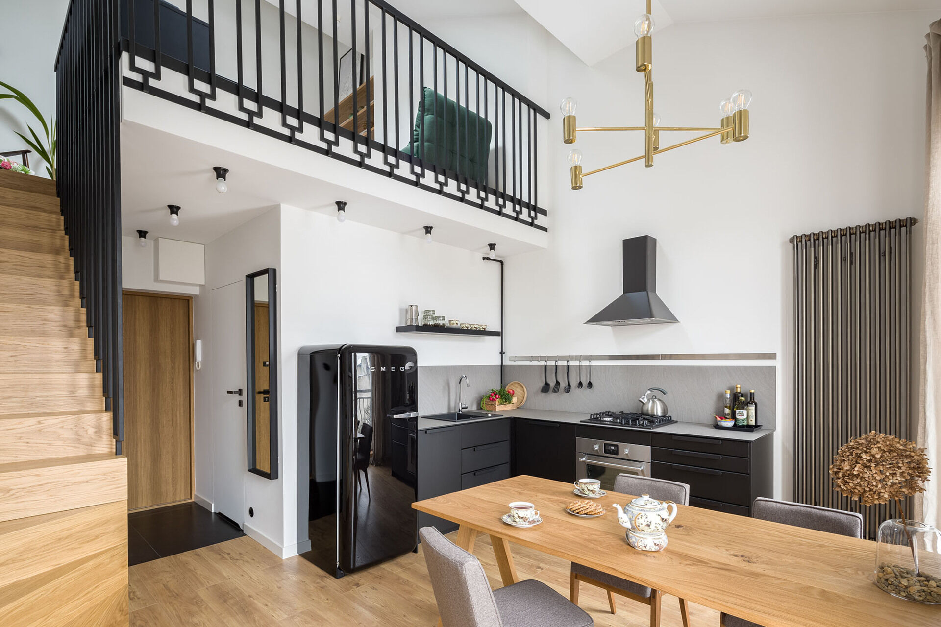 Oak stairs and a custom black steel balustrade add warmth and character to this mezzanine apartment.