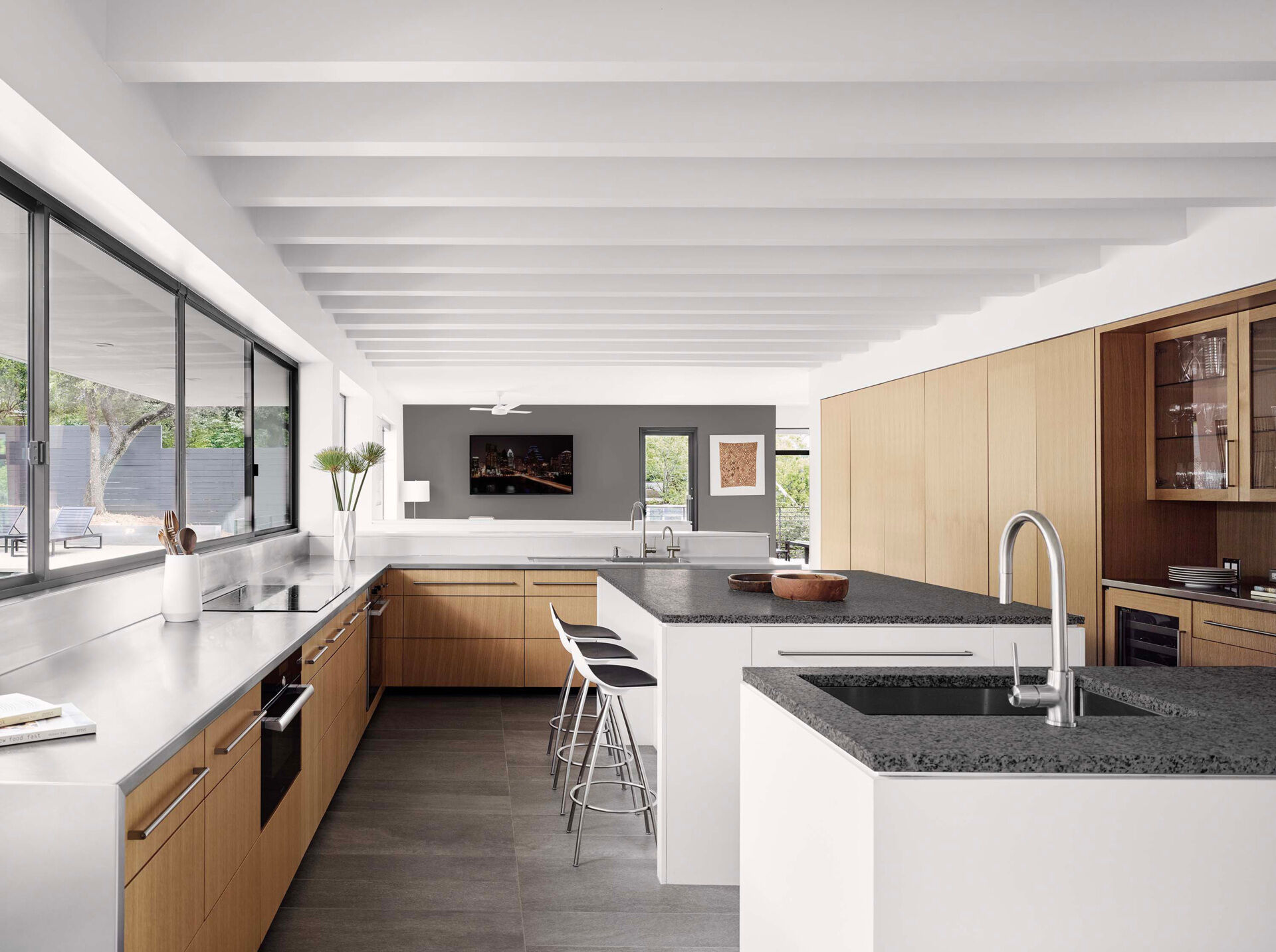 Esta casa de Austin cuenta con una gran cocina con ventana de servicio y acceso directo al patio de la piscina para facilitar el entretenimiento.