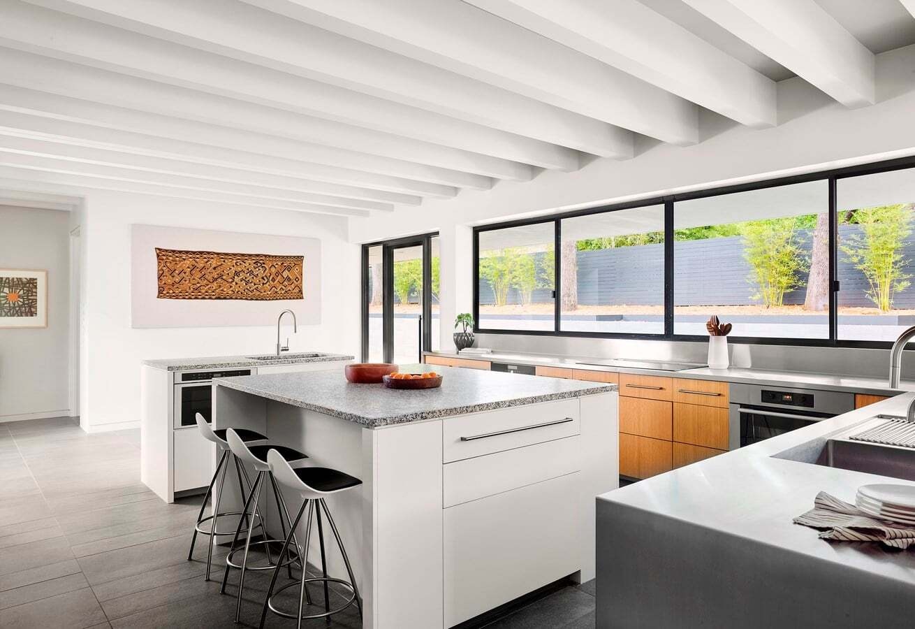 Esta casa de Austin cuenta con una gran cocina con ventana de servicio y acceso directo al patio de la piscina para facilitar el entretenimiento.