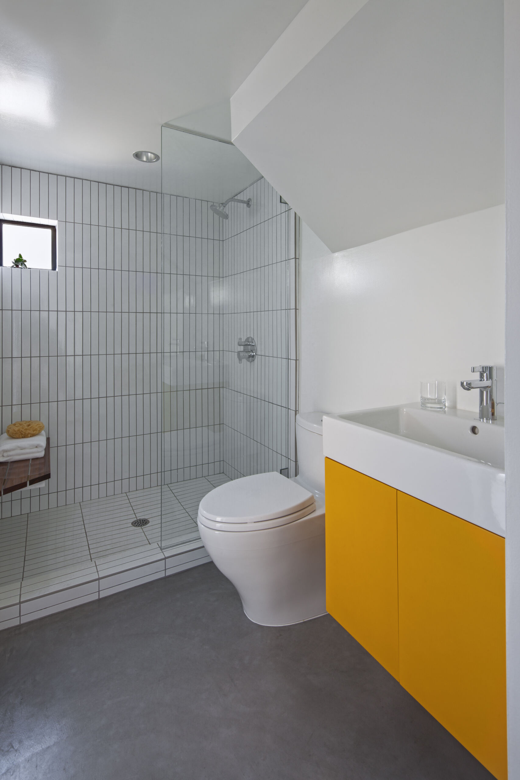 Vertical shower tiles help create a sense of height in the compact bathroom of this Venice micro apartment.