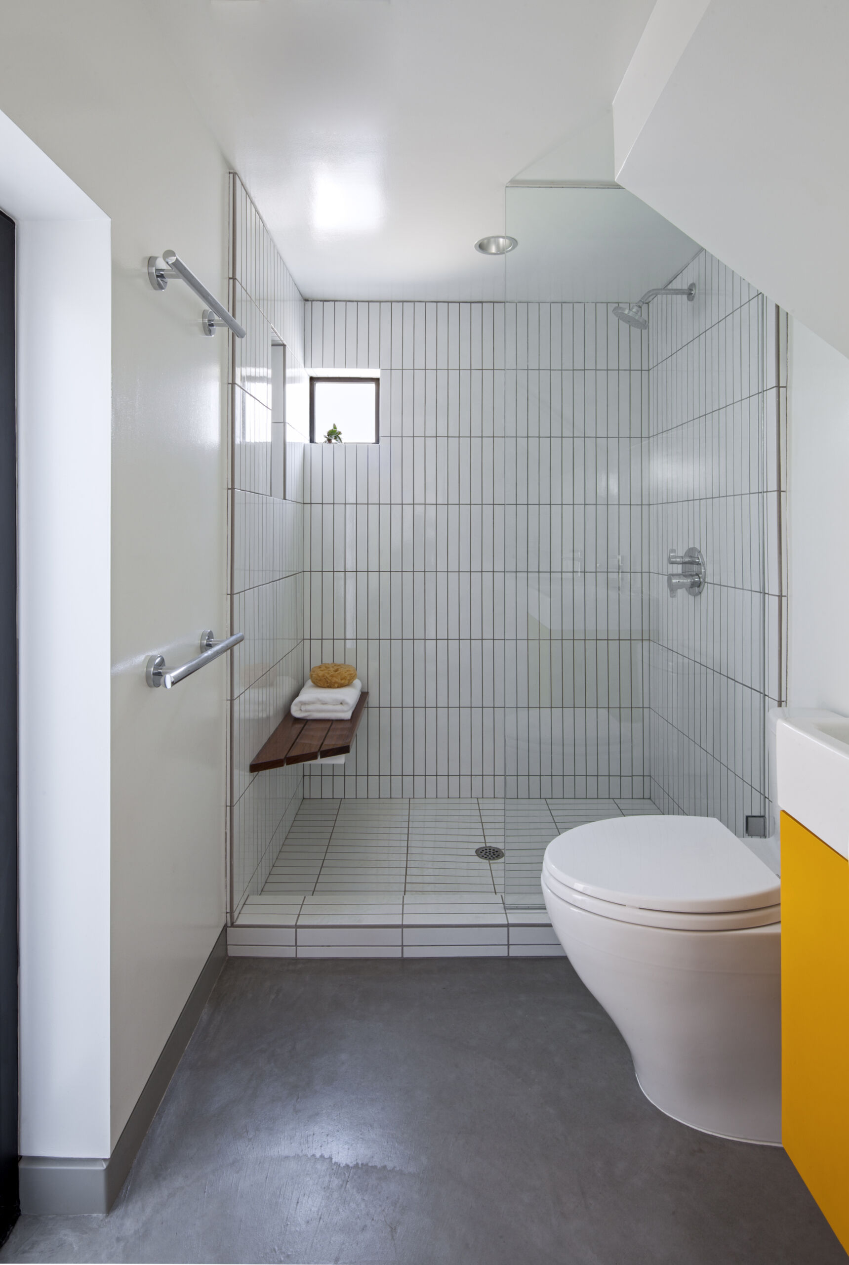 Vertical shower tiles help create a sense of height in the compact bathroom of this Venice micro apartment.