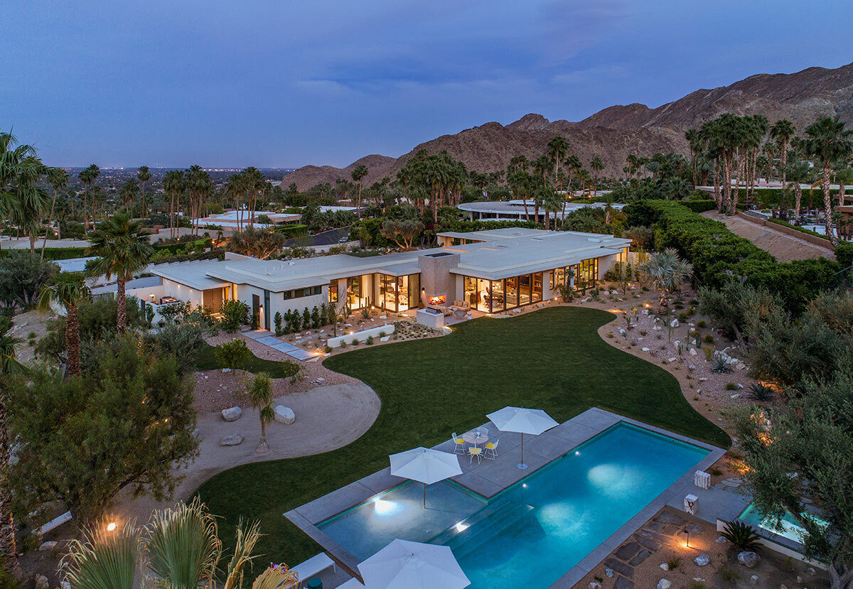 A spacious desert backyard with lawn, swimming pool, and outdoor living areas.