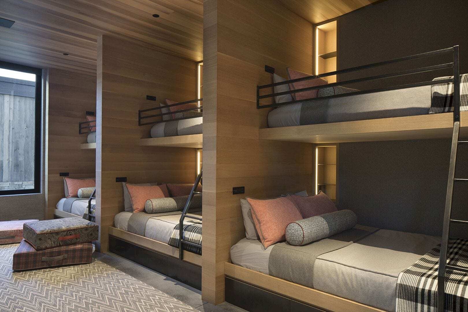 Las literas diseñadas a medida con estantes individuales permiten que este amplio dormitorio aloje cómodamente a seis o más huéspedes.