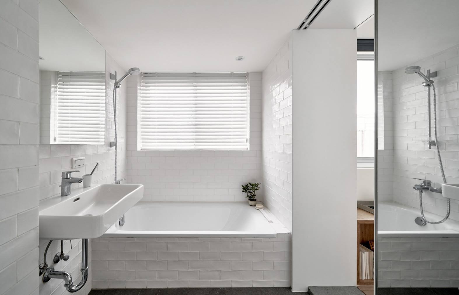 White walls and smart layout choices make this small Taipei bathroom feel bright and functional, complete with open shelving and a bath shower combo.