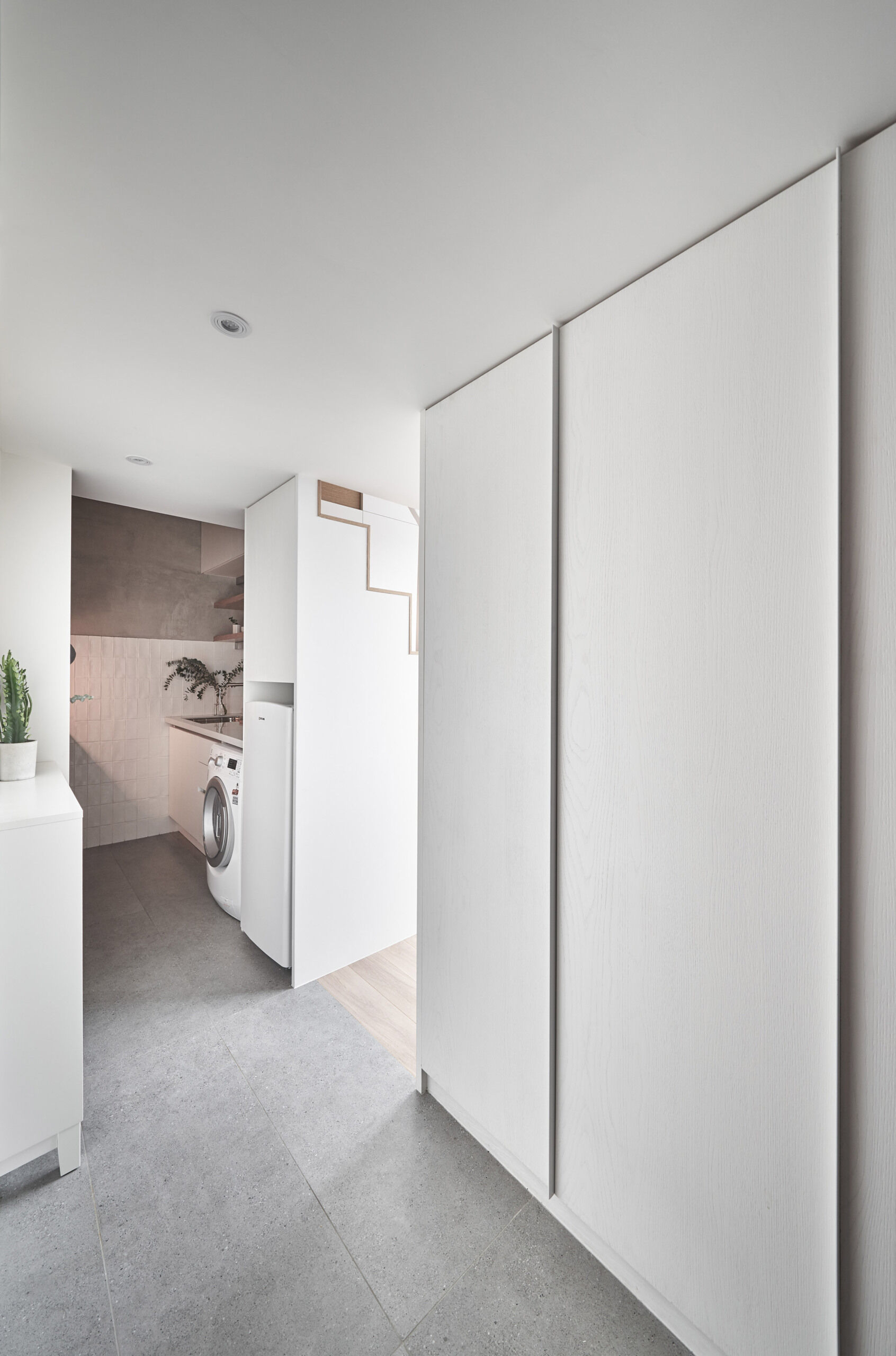 A minimalist entryway with hidden storage sets the tone for this small Taipei apartment, using clean white doors to keep the space feeling calm and uncluttered.