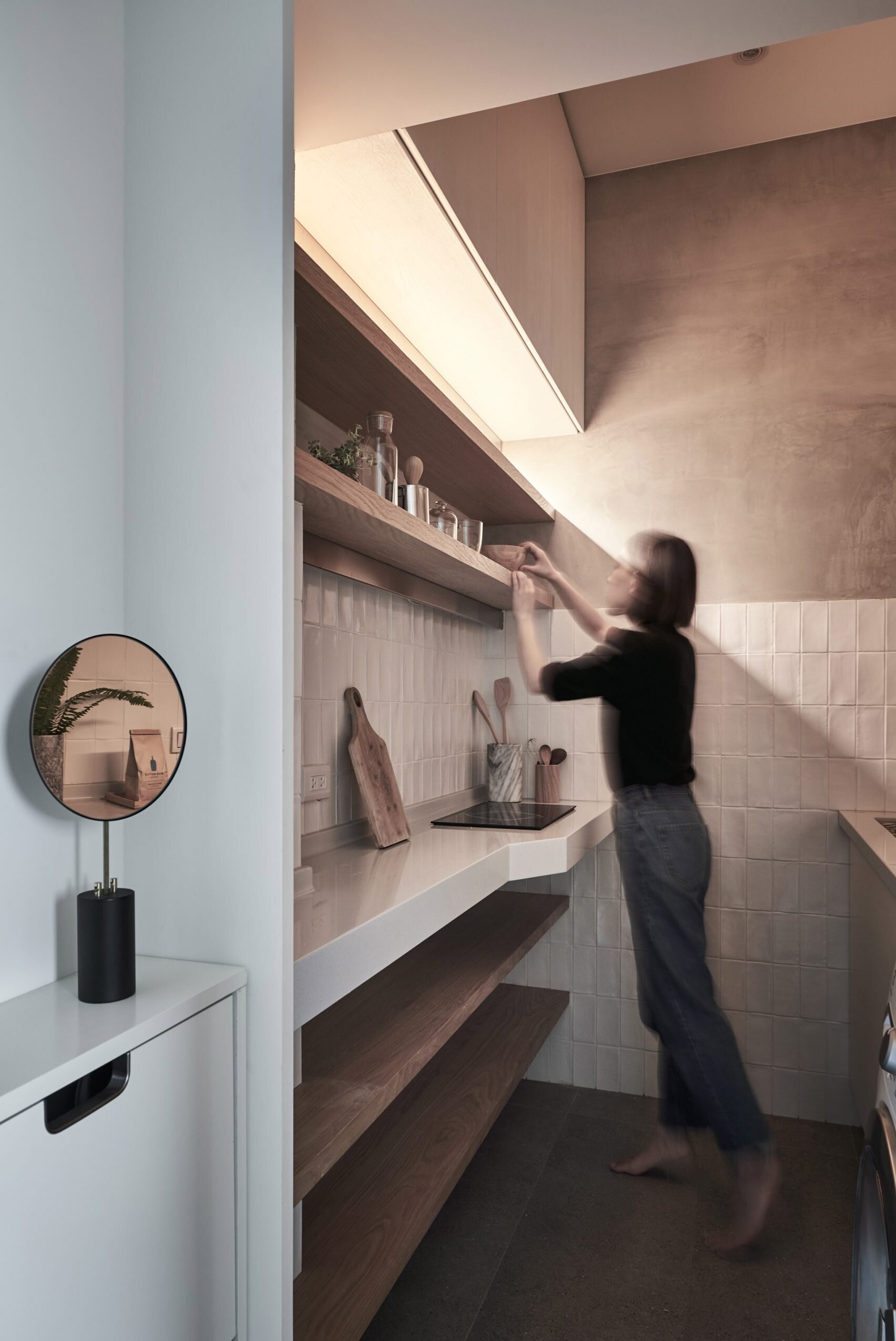 This tiny Taipei kitchen fits a fridge, washer dryer and stove into a streamlined layout that balances warm wood shelving with practical storage.