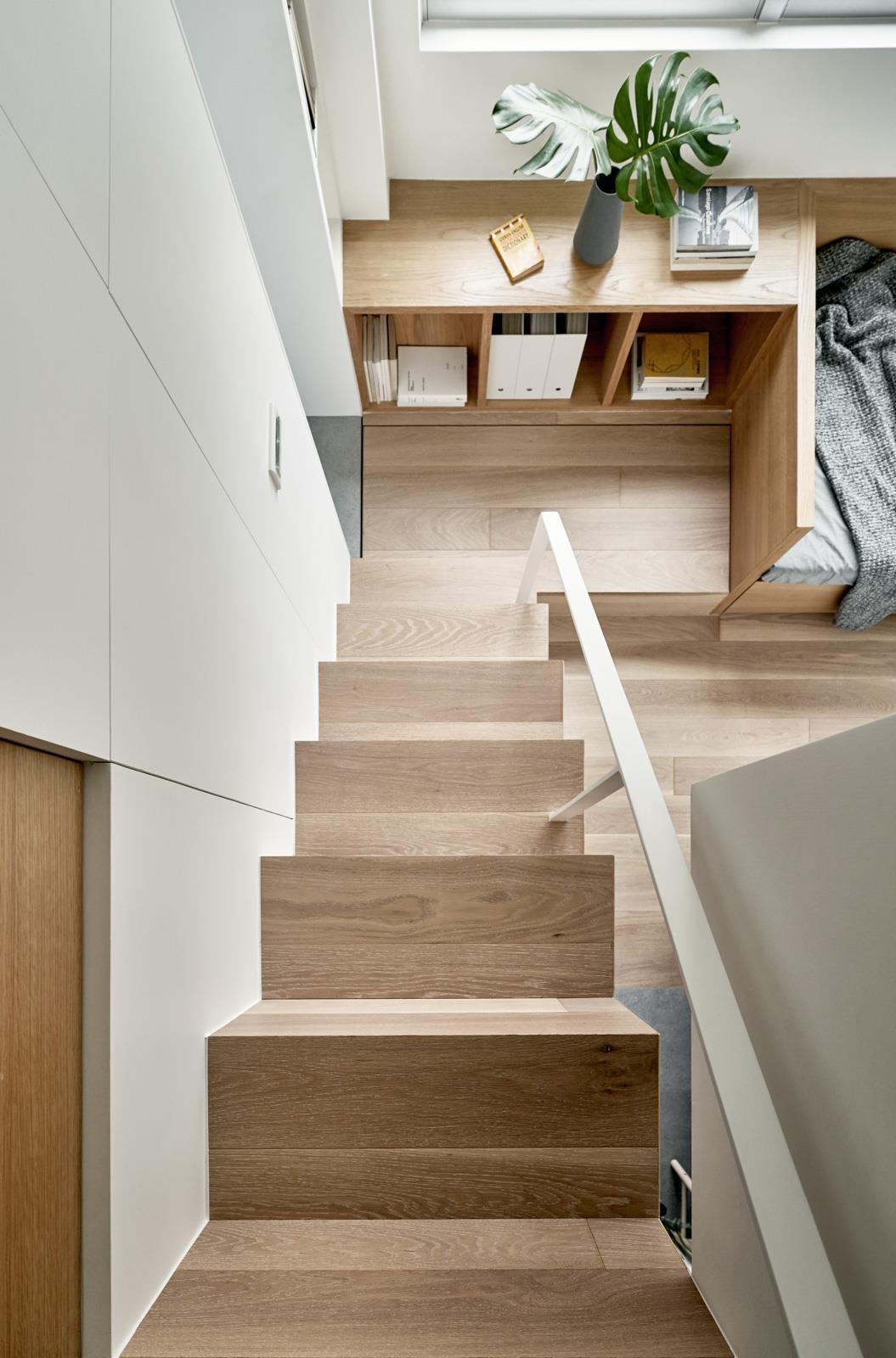 Wood stairs in this Taipei micro flat hide built in storage and appliances, proving every element can serve more than one purpose.