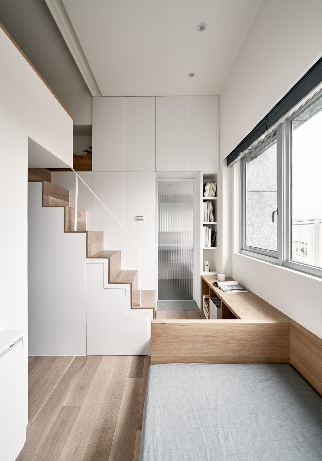 Clever hidden storage solutions make this 189 square foot Taipei apartment feel surprisingly spacious, with cupboards built into stairs, walls and floors.