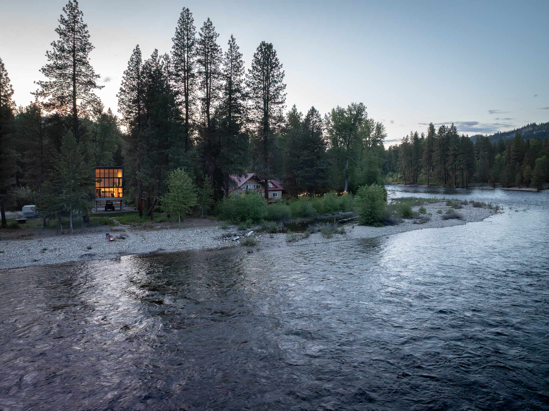 An elevated cabin in Plain, Washington rises above the Wenatchee River floodplain, using cedar, steel, and concrete to live lightly within the forest.