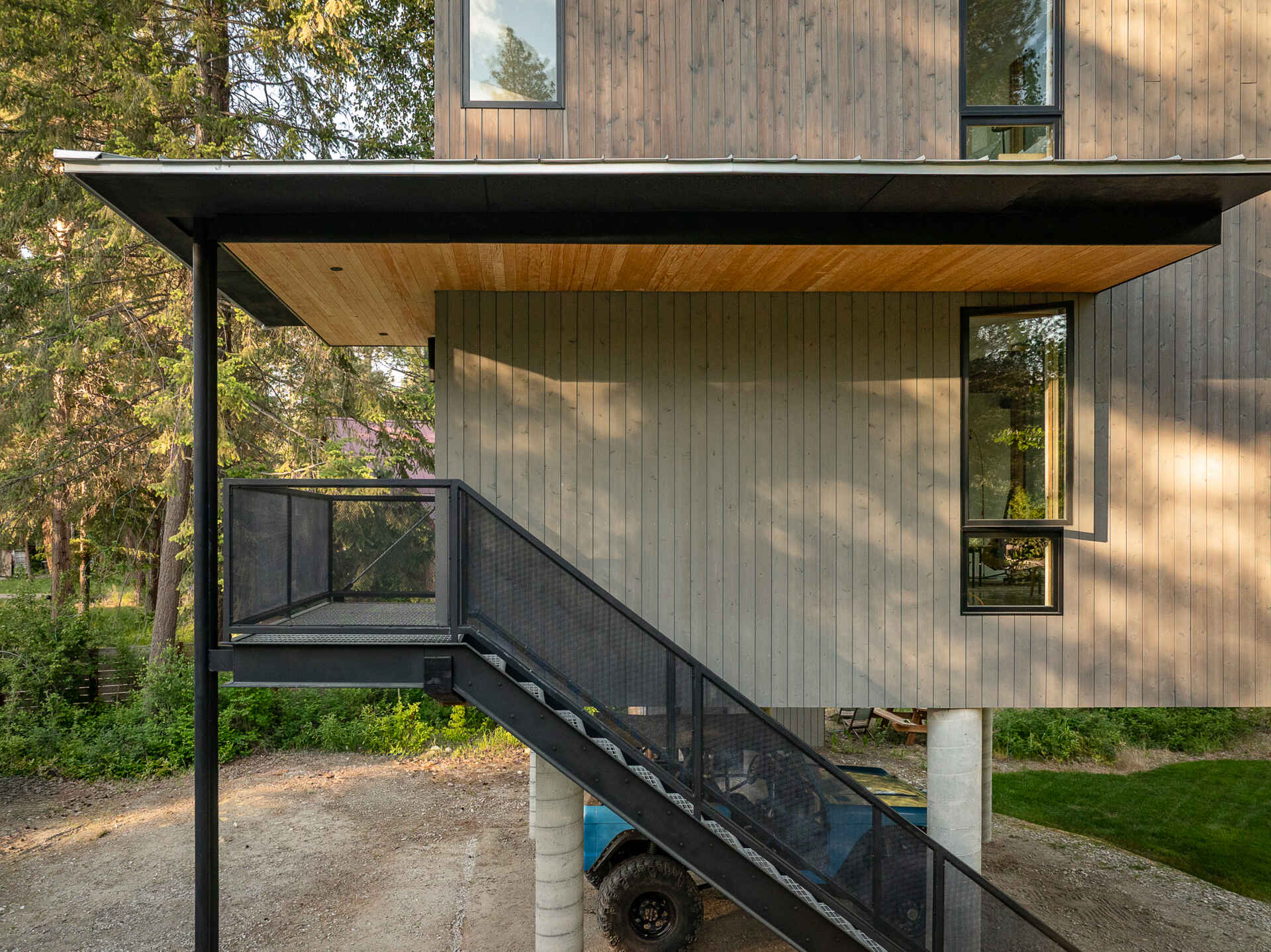 An elevated cabin in Plain, Washington rises above the Wenatchee River floodplain, using cedar, steel, and concrete to live lightly within the forest.