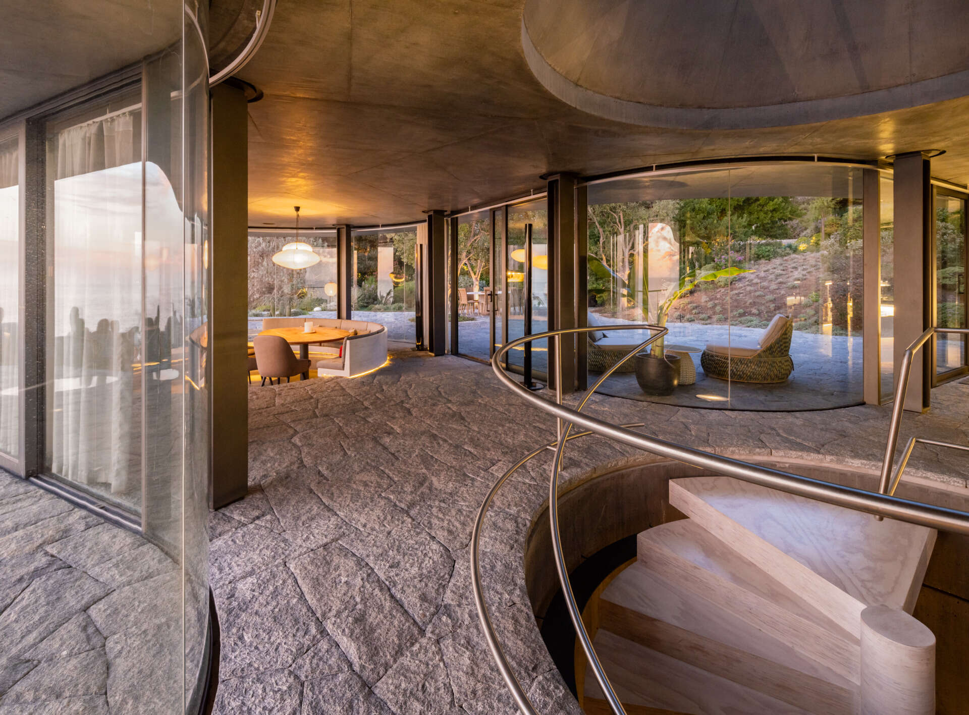 A curved dining space with built-in a banquette is designed to stay visually connected to the sea from every angle.