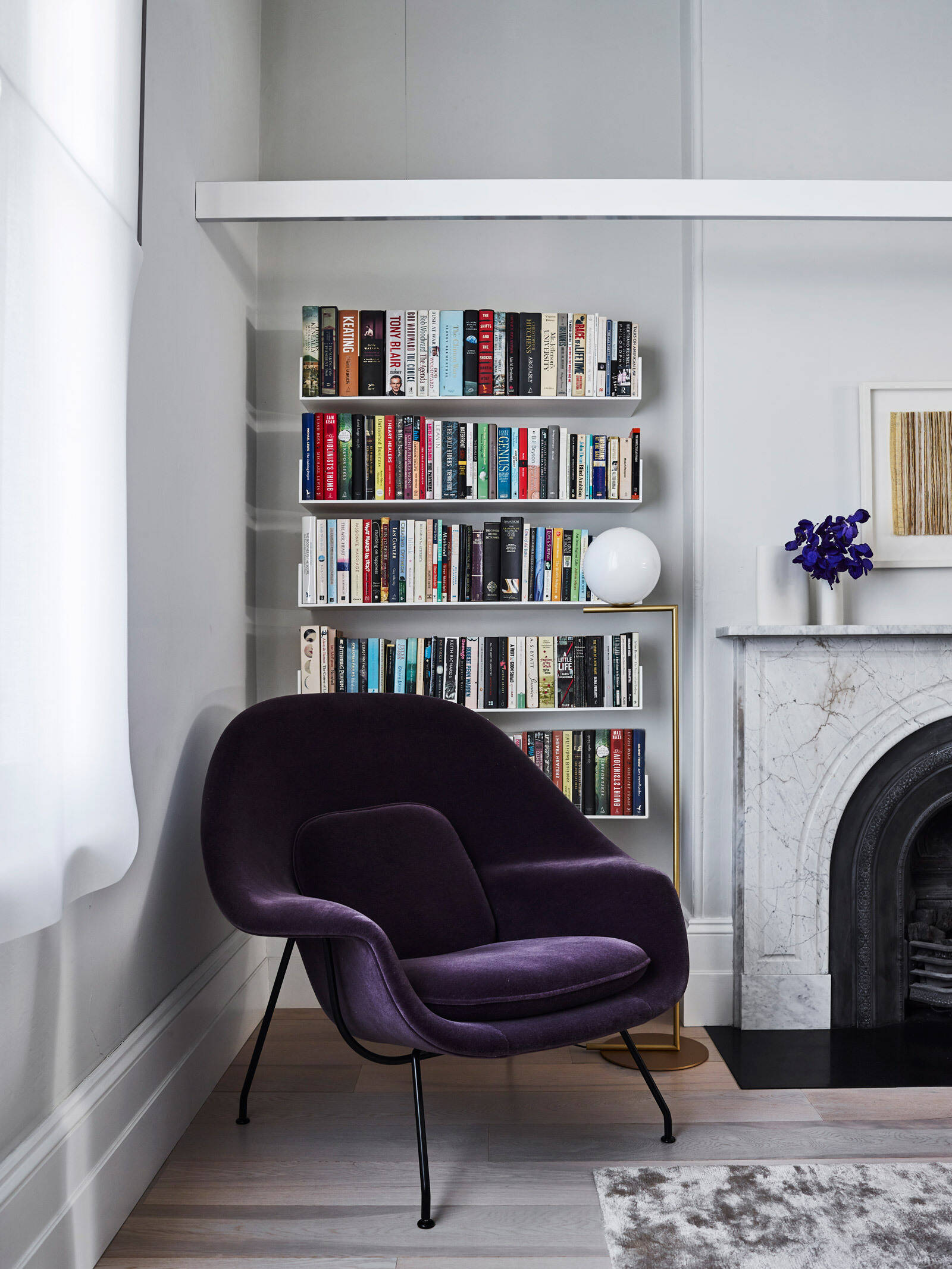 Una oficina en casa llena de luz diseñada para exhibir arte en un interior neutro.