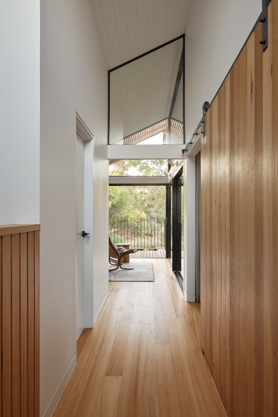 Hay una pequeña zona para sentarse al final del pasillo de arriba que da a la sala de estar de abajo y conduce al balcón.