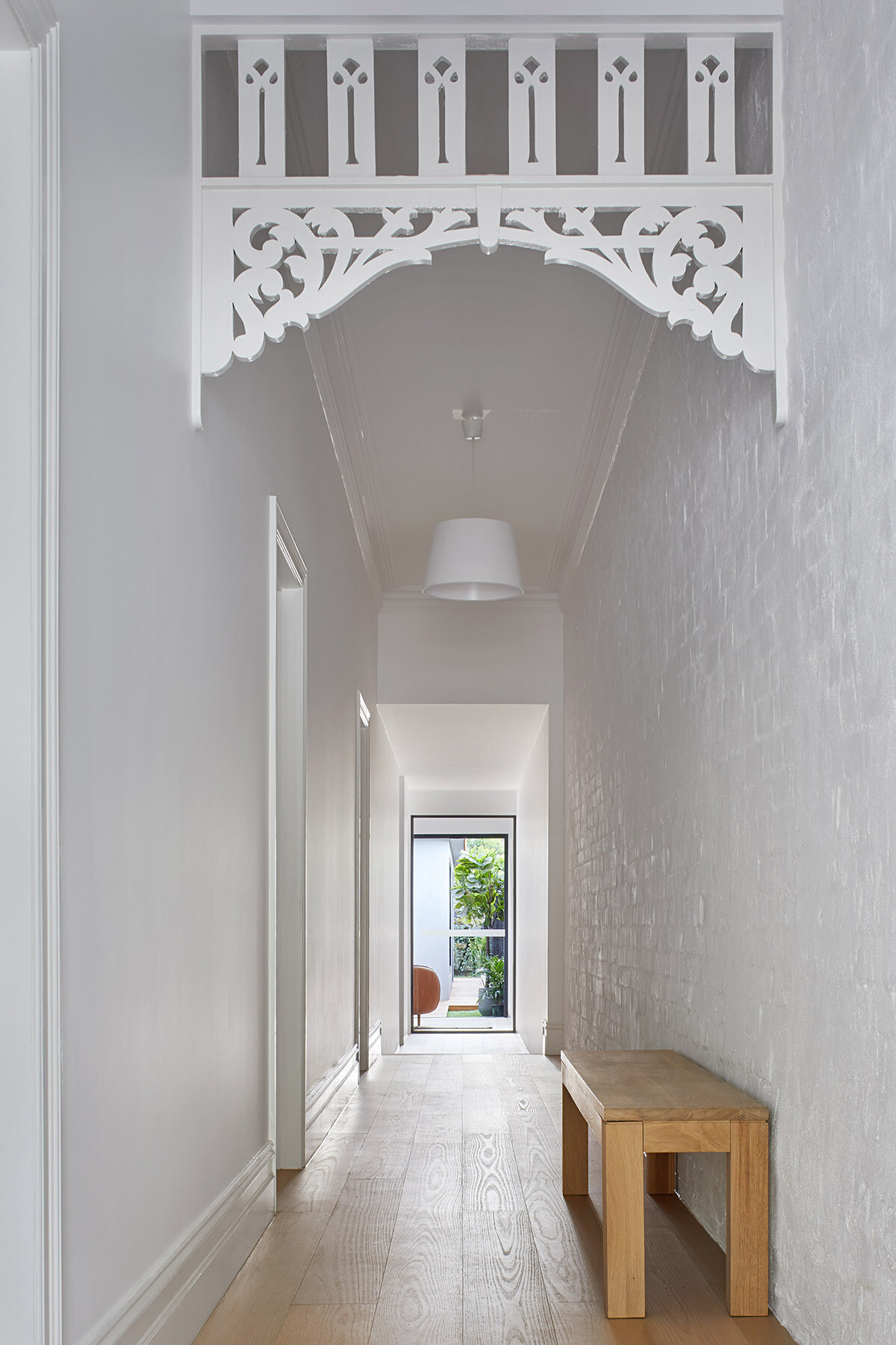 A white hallway with original Victorian details leads through this Melbourne cottage, setting up a quiet transition from old to new.