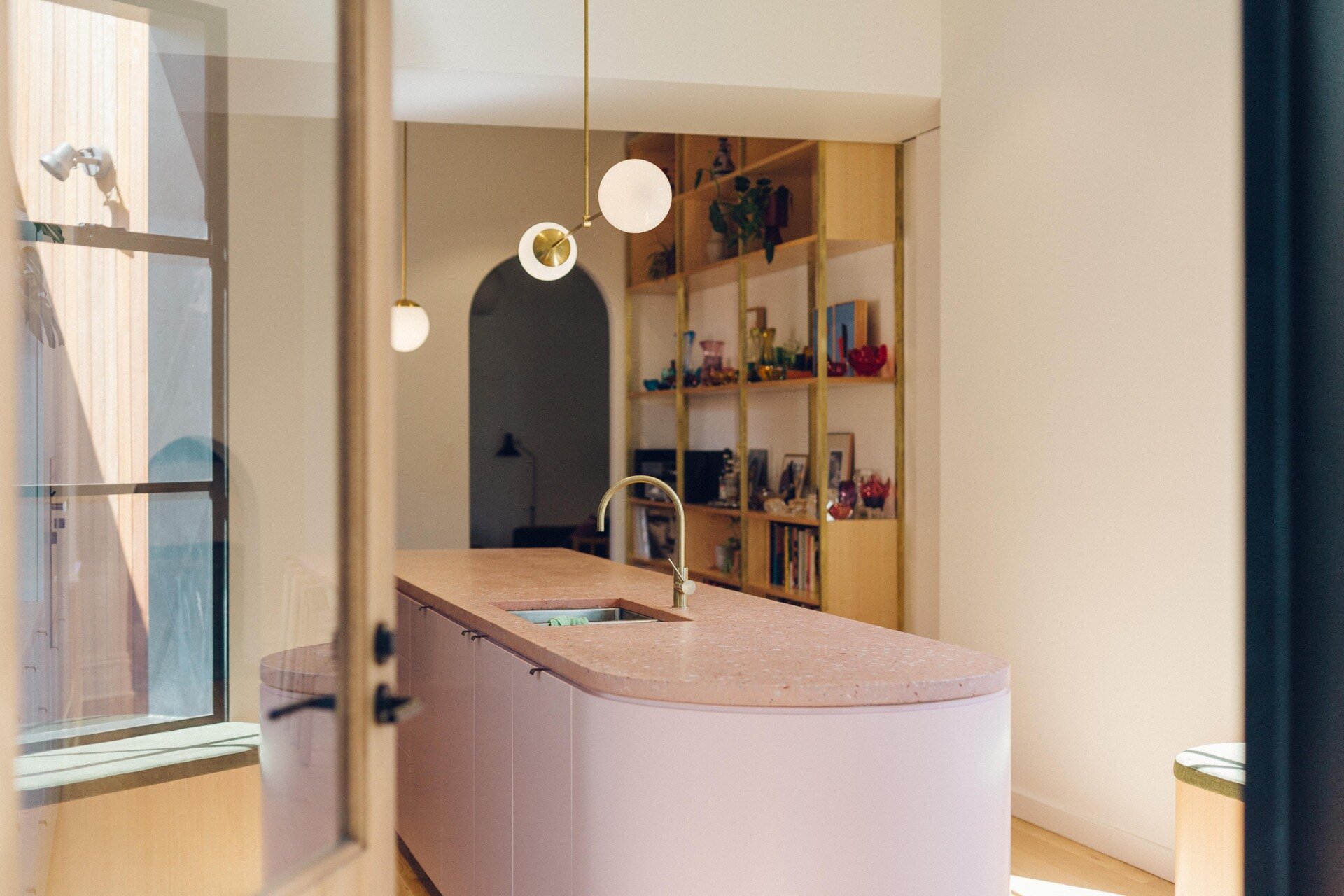 Timber shelving showcases Italian and Czech glassware alongside German pottery and books.
