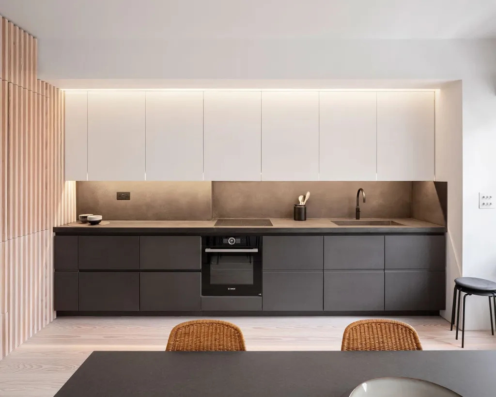 All kitchen appliances and hanging cupboards are cleverly incorporated into the timber wall, keeping the apartment efficient and uncluttered.