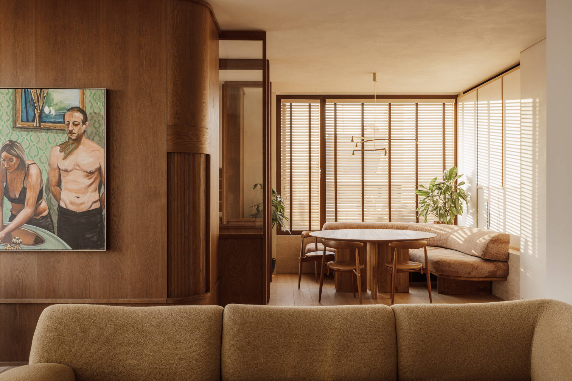 A custom corner banquette dining nook seamlessly integrated into a flowing living space, designed for long meals and easy gatherings.