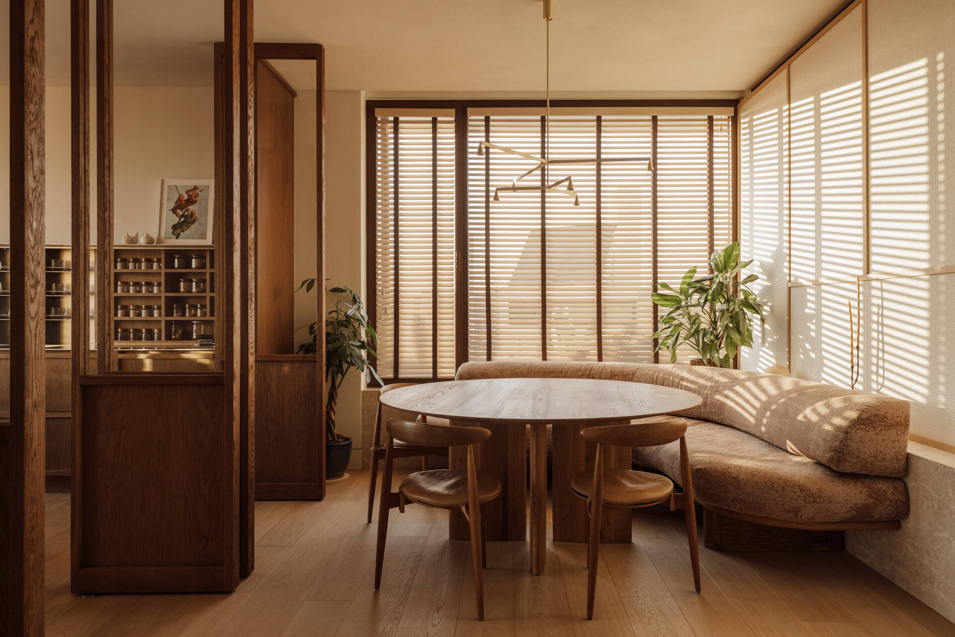 A custom corner banquette dining nook seamlessly integrated into a flowing living space, designed for long meals and easy gatherings.