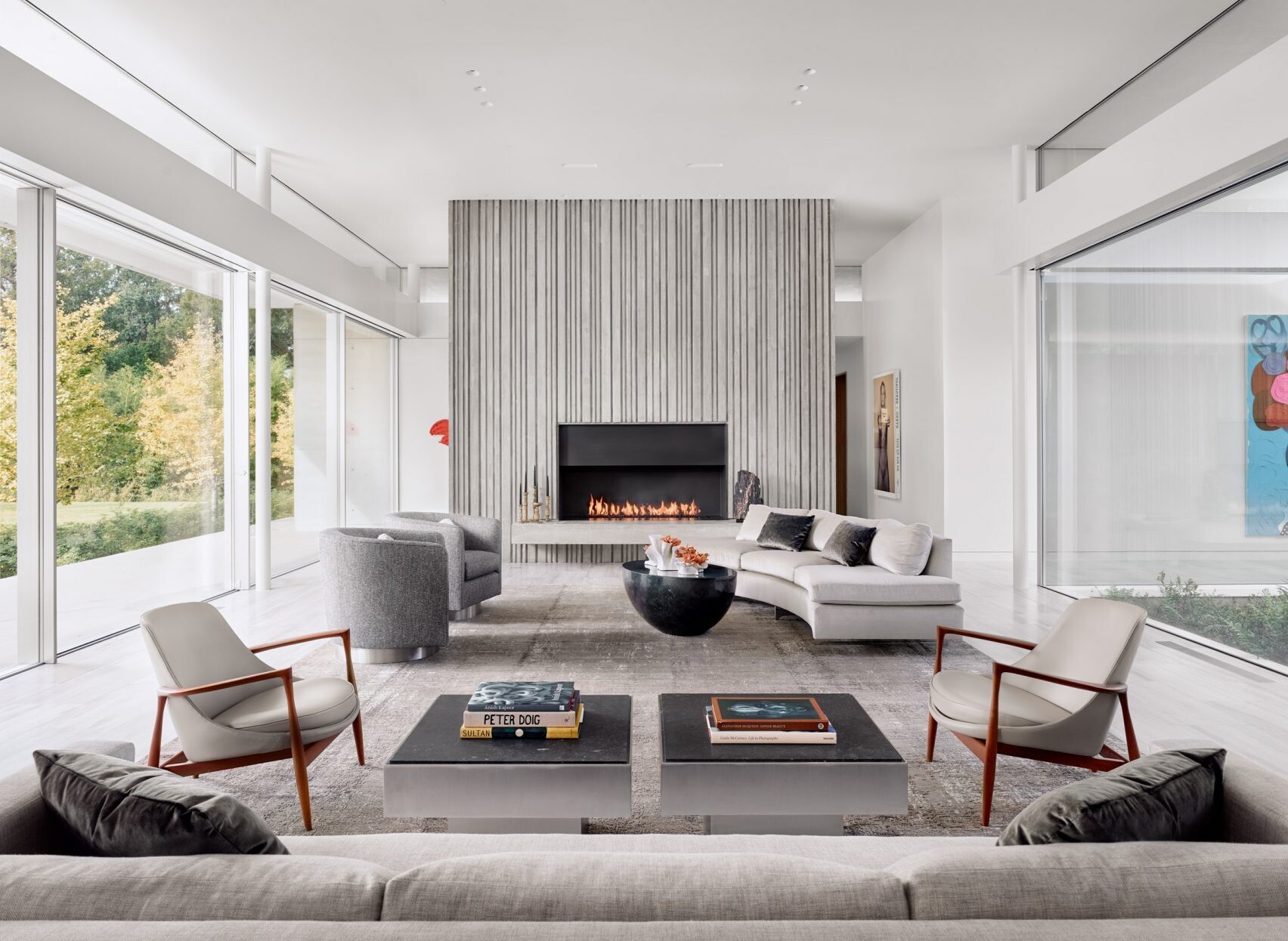 Inside the living room, a corrugated concrete fireplace surround adds vertical texture and height, echoing the exterior walls and unifying the design.