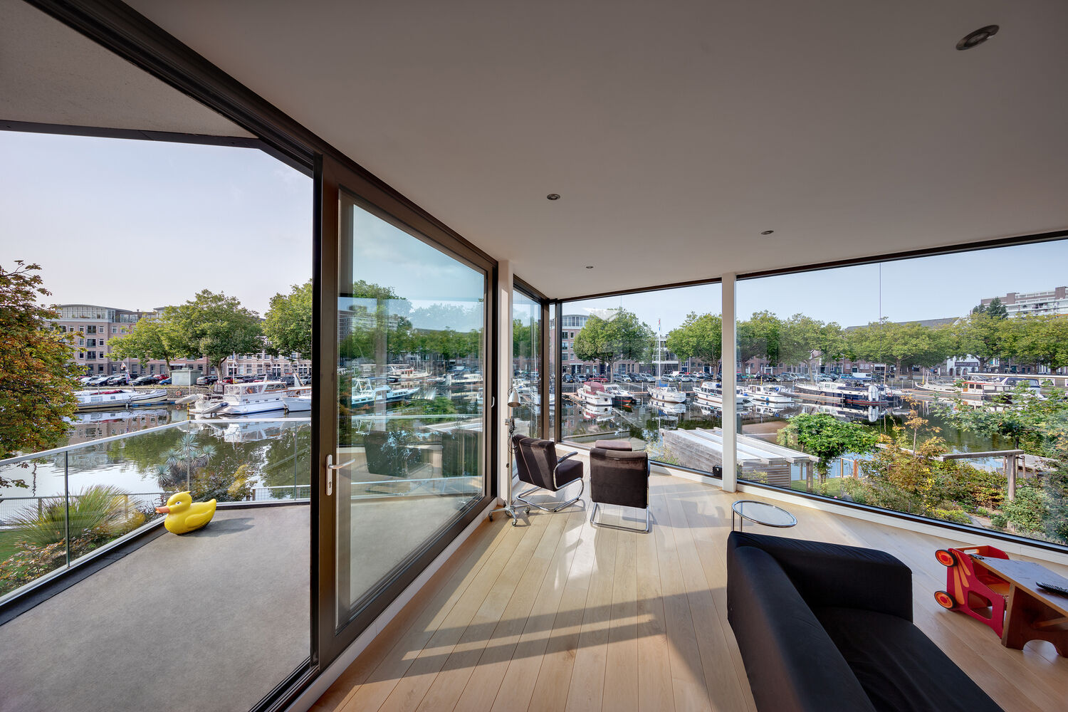 The rotated middle floor creates unexpected sightlines through the home. Panoramic glazing draws in treetops and water, turning the interior into a light filled, widescreen living space.