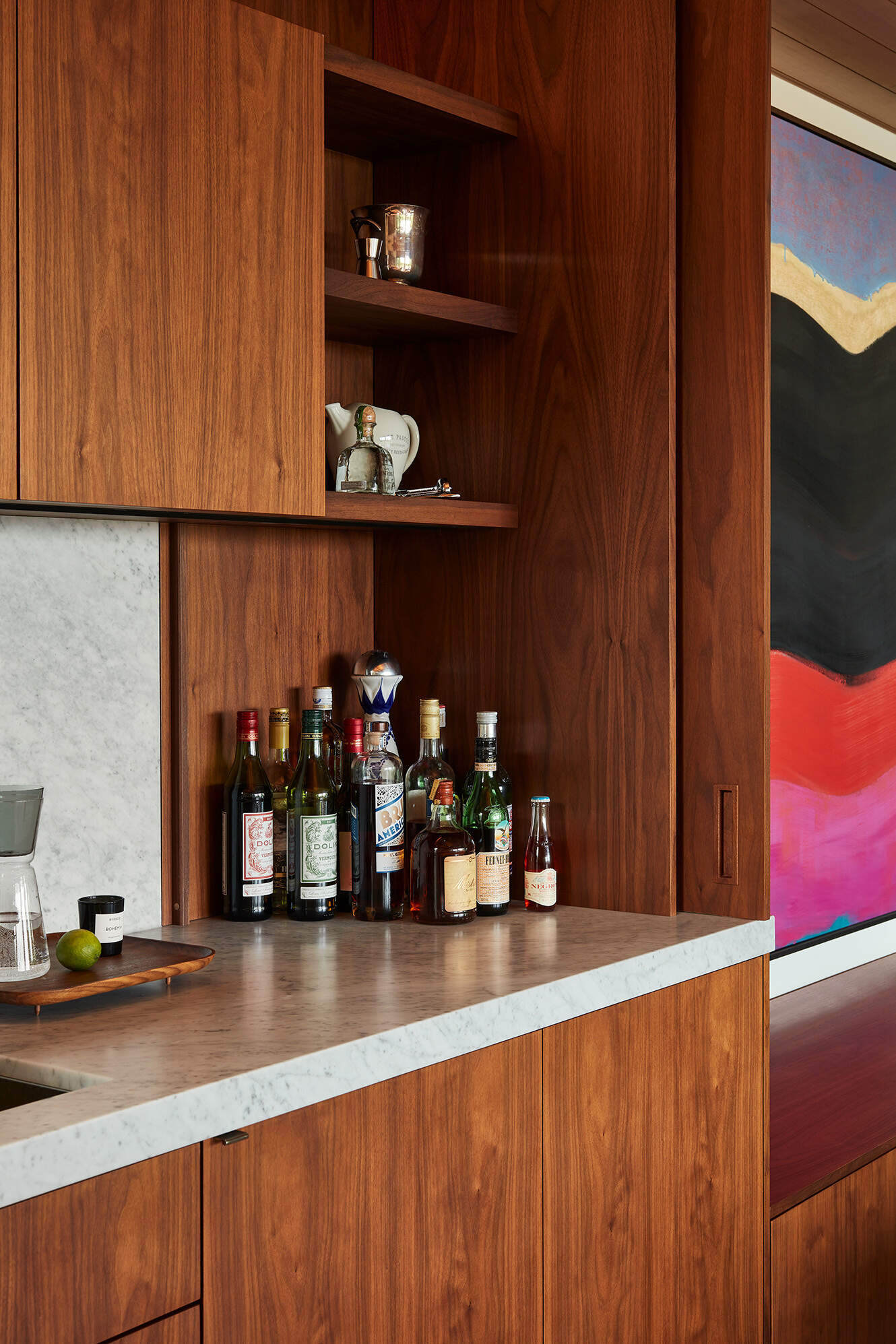 Los gabinetes personalizados continúan con el tema de la funcionalidad oculta. Un mueble bar con puertas plegables puede transformar el espacio durante las reuniones navideñas.