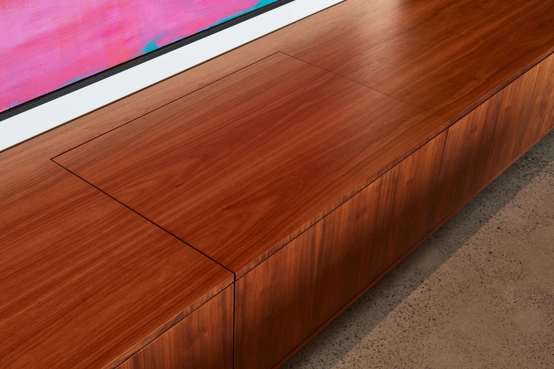 Las habitaciones se abren al paisaje y al campo, favoreciendo el fácil movimiento entre el interior y el exterior. Un mueble bajo con un tocadiscos incorporado se alinea en la pared, añadiendo un toque personal a la sala de estar de planta abierta.