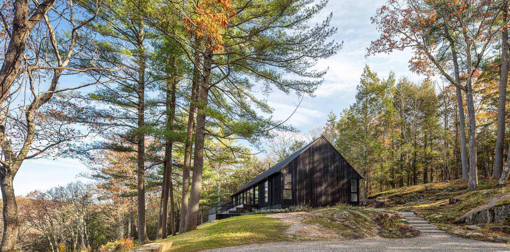 A modern home in Cornwall, Connecticut, built directly on a dramatic rock ledge. Inspired by local barns and the historic West Cornwall Covered Bridge, this forest retreat blends charred wood siding with contemporary design.