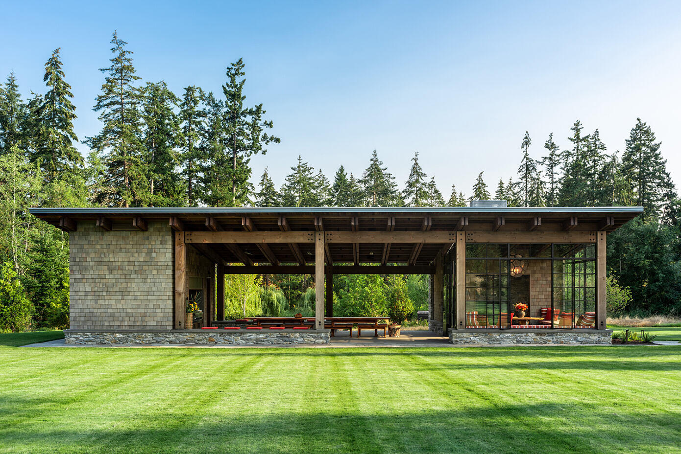 Inspired by Civilian Conservation Corps park structures, this Pacific Northwest pavilion blends rugged stone, timber and a simple shed roof form for a timeless look rooted in nature.
