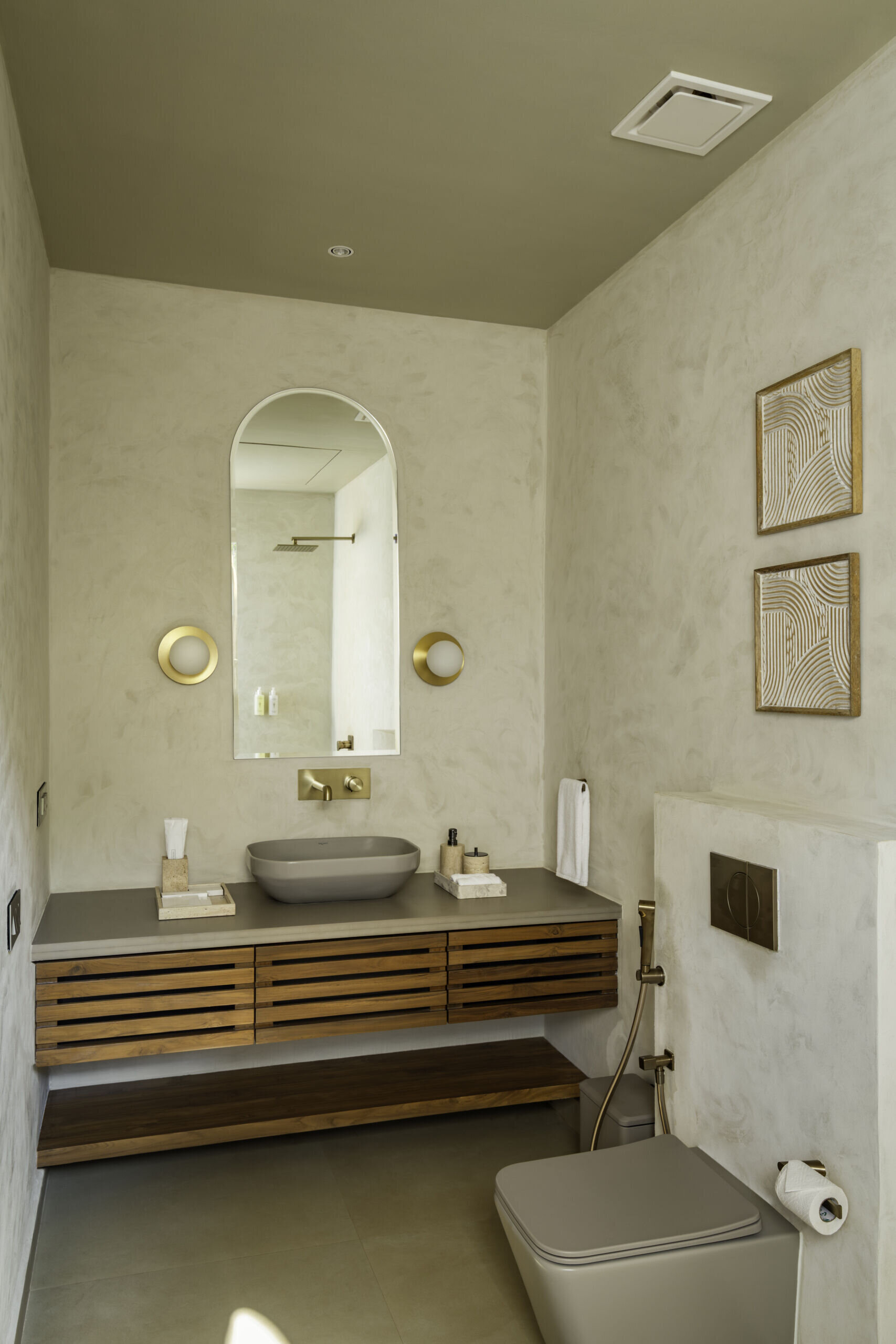 Seamless concrete curves, lime plaster walls and in-situ terrazzo basins shape cocoon-like bathrooms designed around natural light and tactile finishes.