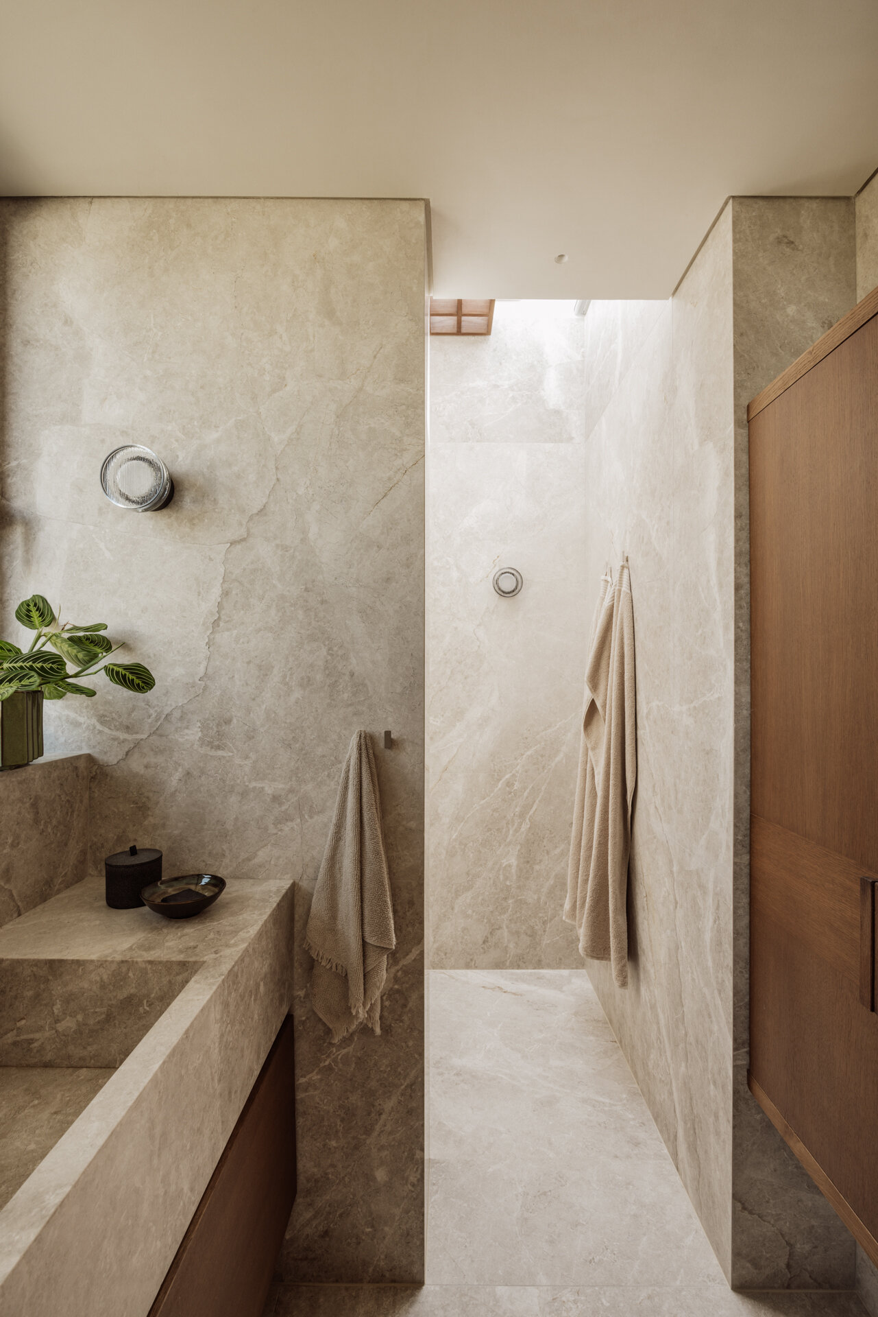 Tactile marble and ceramic bathrooms that continue a biophilic design approach focused on calm and connection to nature.