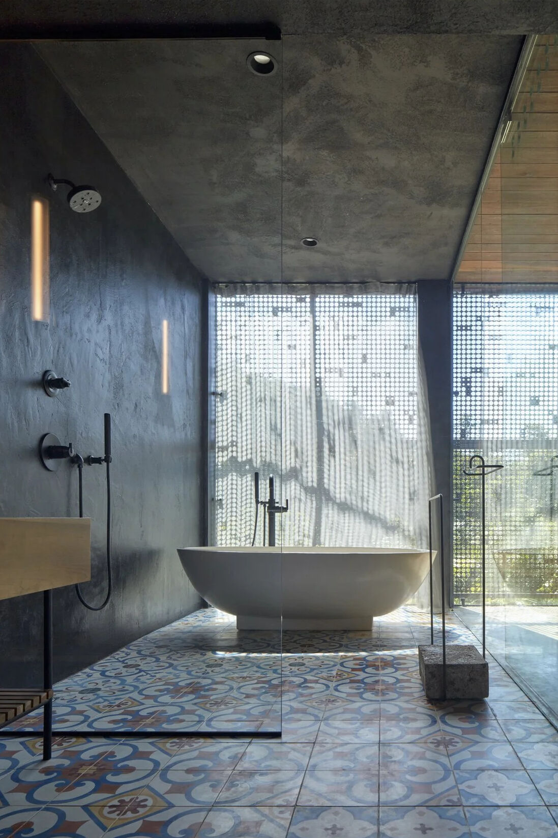 A shared bathroom with dual vanity, walk in shower and freestanding bathtub continues the home’s calm, natural material palette.
