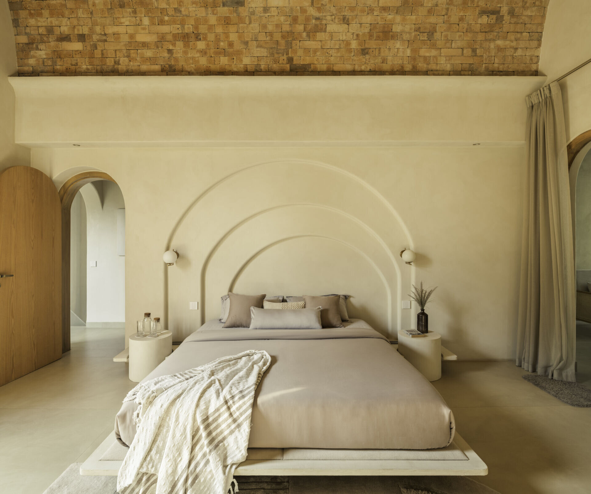 Each bedroom embraces artisan plasters, cane, wood and linen within a shared earthy palette, creating cool, monastic and cave-like atmospheres rooted in tactile comfort.