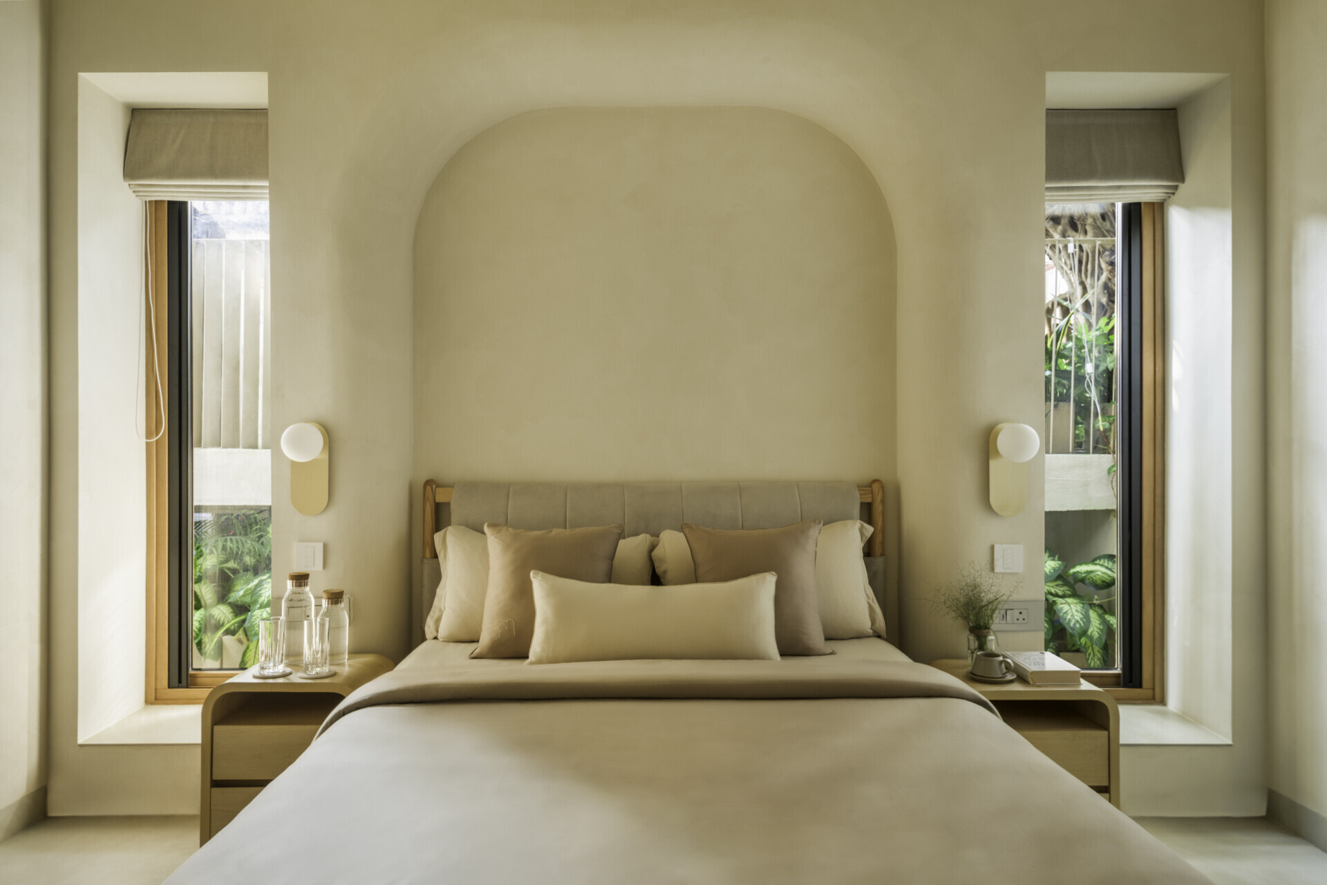 Each bedroom embraces artisan plasters, cane, wood and linen within a shared earthy palette, creating cool, monastic and cave-like atmospheres rooted in tactile comfort.