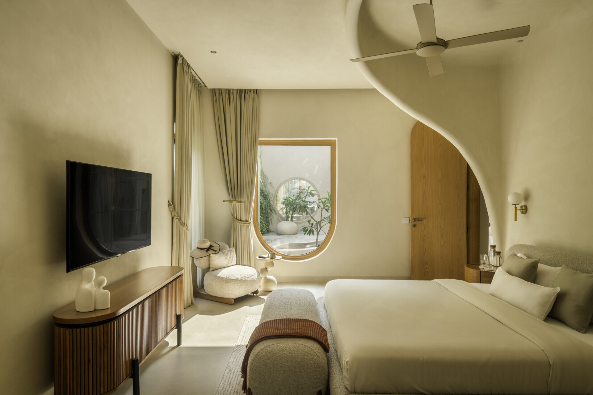 Each bedroom embraces artisan plasters, cane, wood and linen within a shared earthy palette, creating cool, monastic and cave-like atmospheres rooted in tactile comfort.