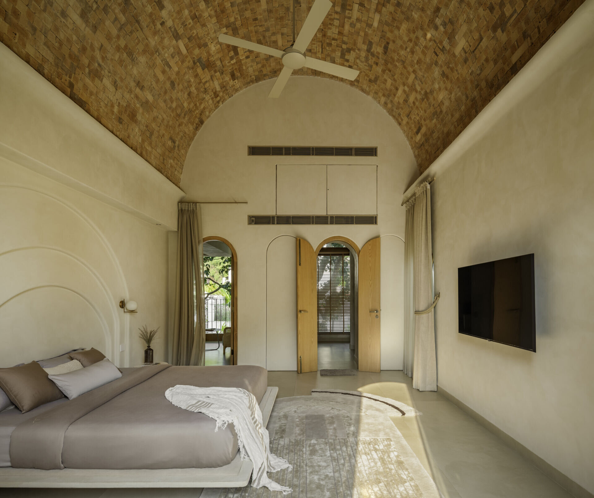 Each bedroom embraces artisan plasters, cane, wood and linen within a shared earthy palette, creating cool, monastic and cave-like atmospheres rooted in tactile comfort.
