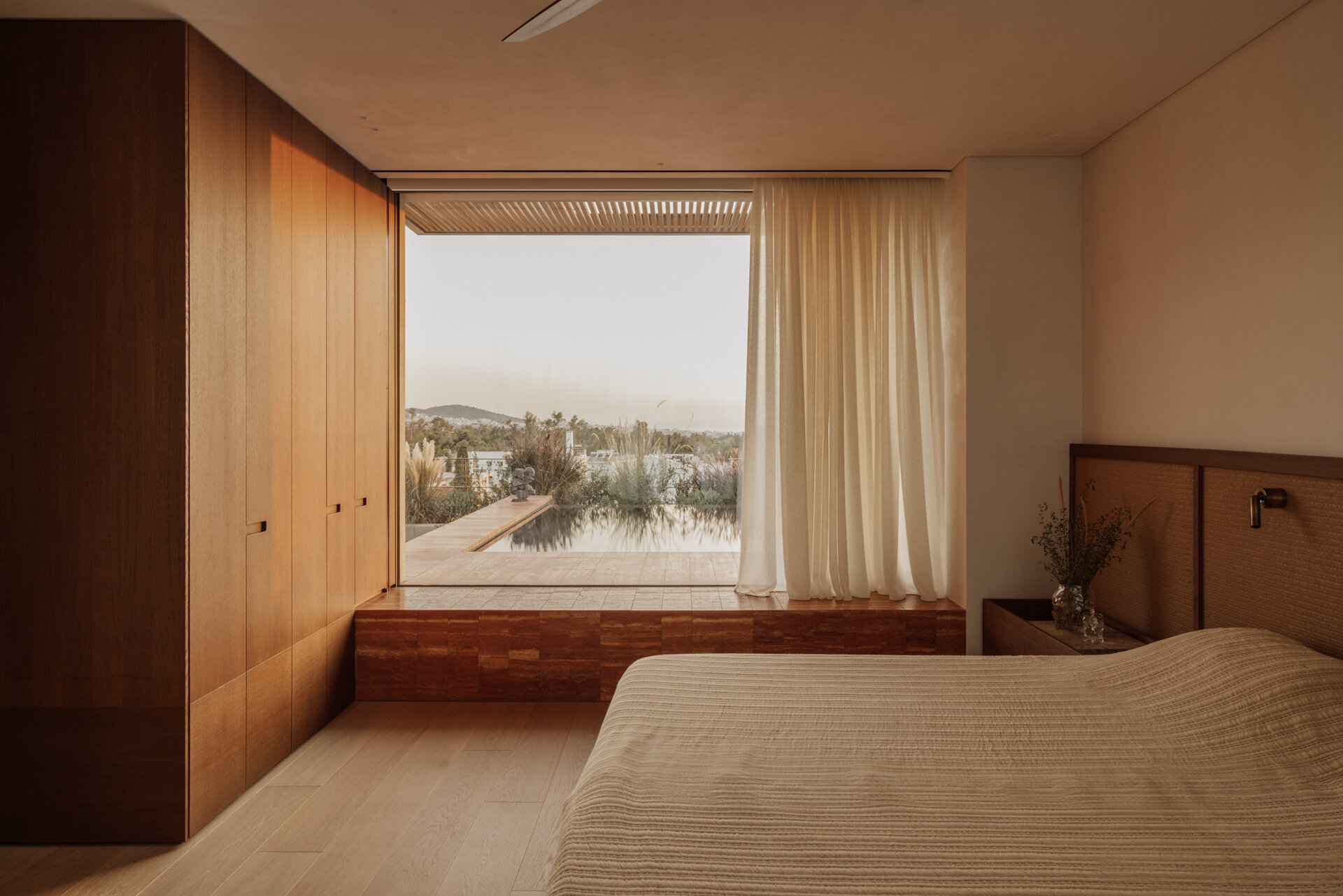 A modern bedroom has been finished with wood and earth tones.