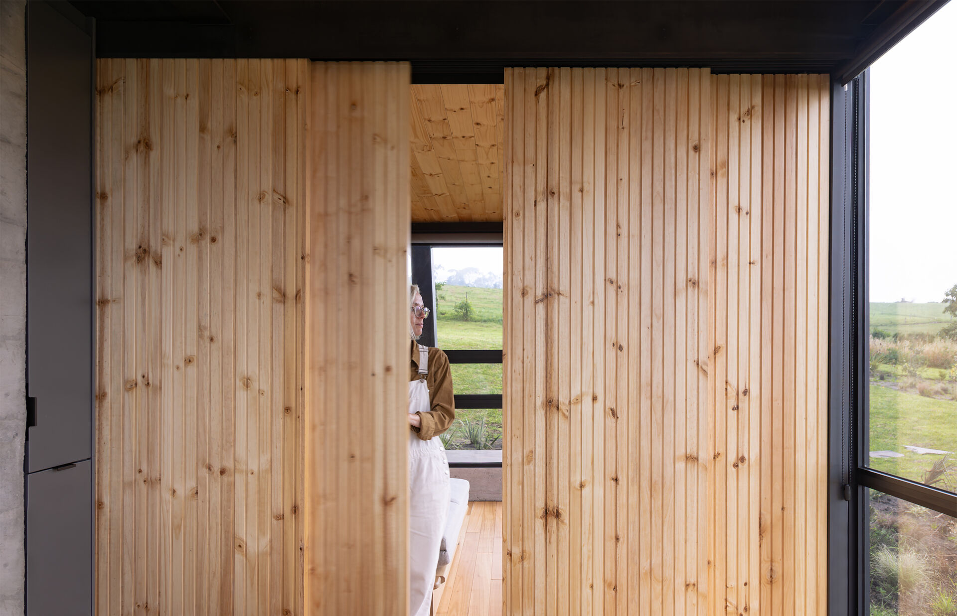The lower level adapts to family visits, creating a flexible gathering space tucked into the slope.