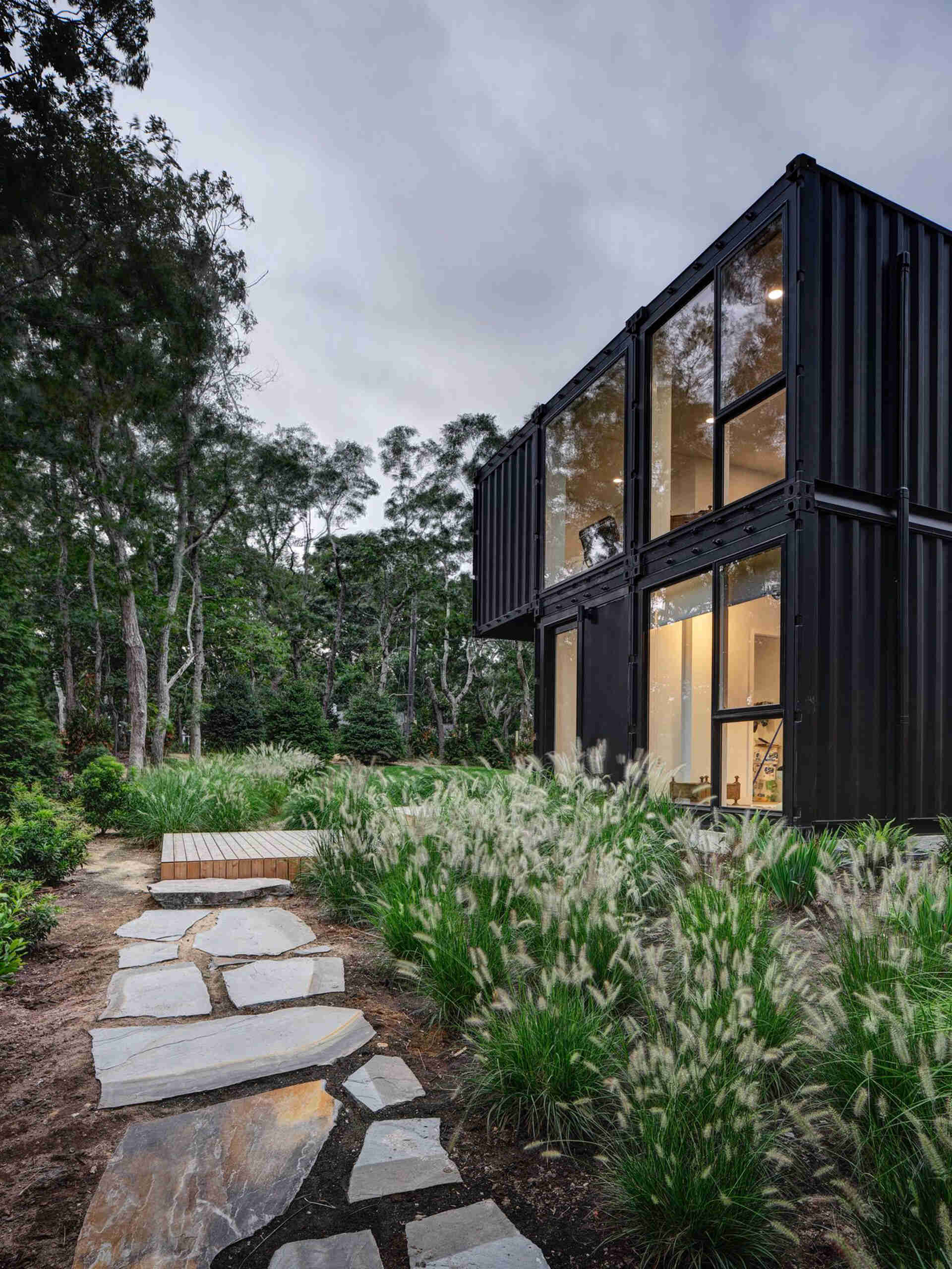 A modern shipping container home designed for a family of five on a wooded New York site. Installed in just two days, this 4-bedroom prefab house proves industrial materials can feel warm and livable.