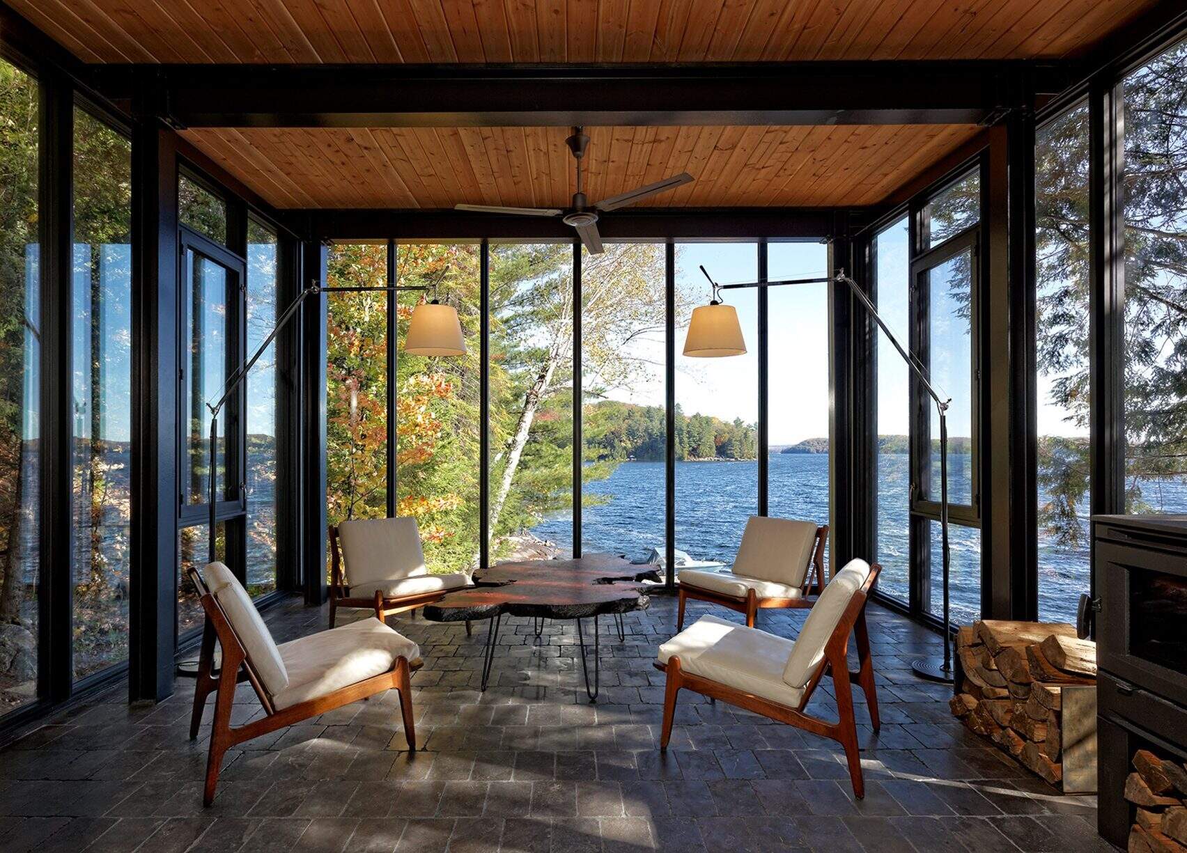 A cozy sitting area with floor to ceiling windows and a fireplace, designed to frame lake views and enhance life on the water.