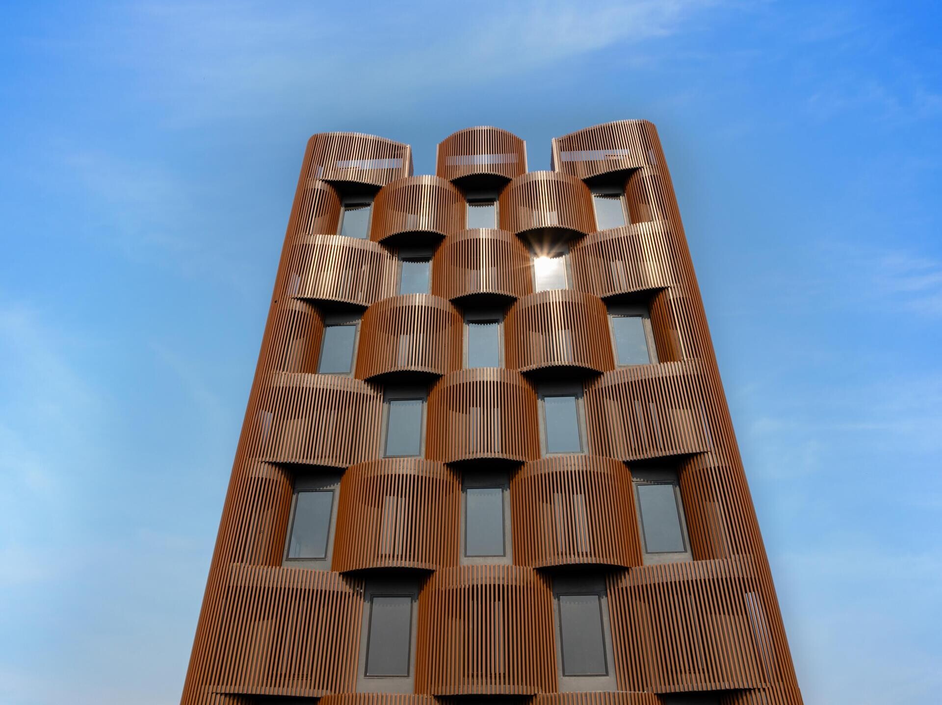 This 14-level office in Nagpur replaces the typical glass facade with layered decks, aluminum louvers, and greenery designed for 48°C summers. A climate-smart approach to modern workplace design.