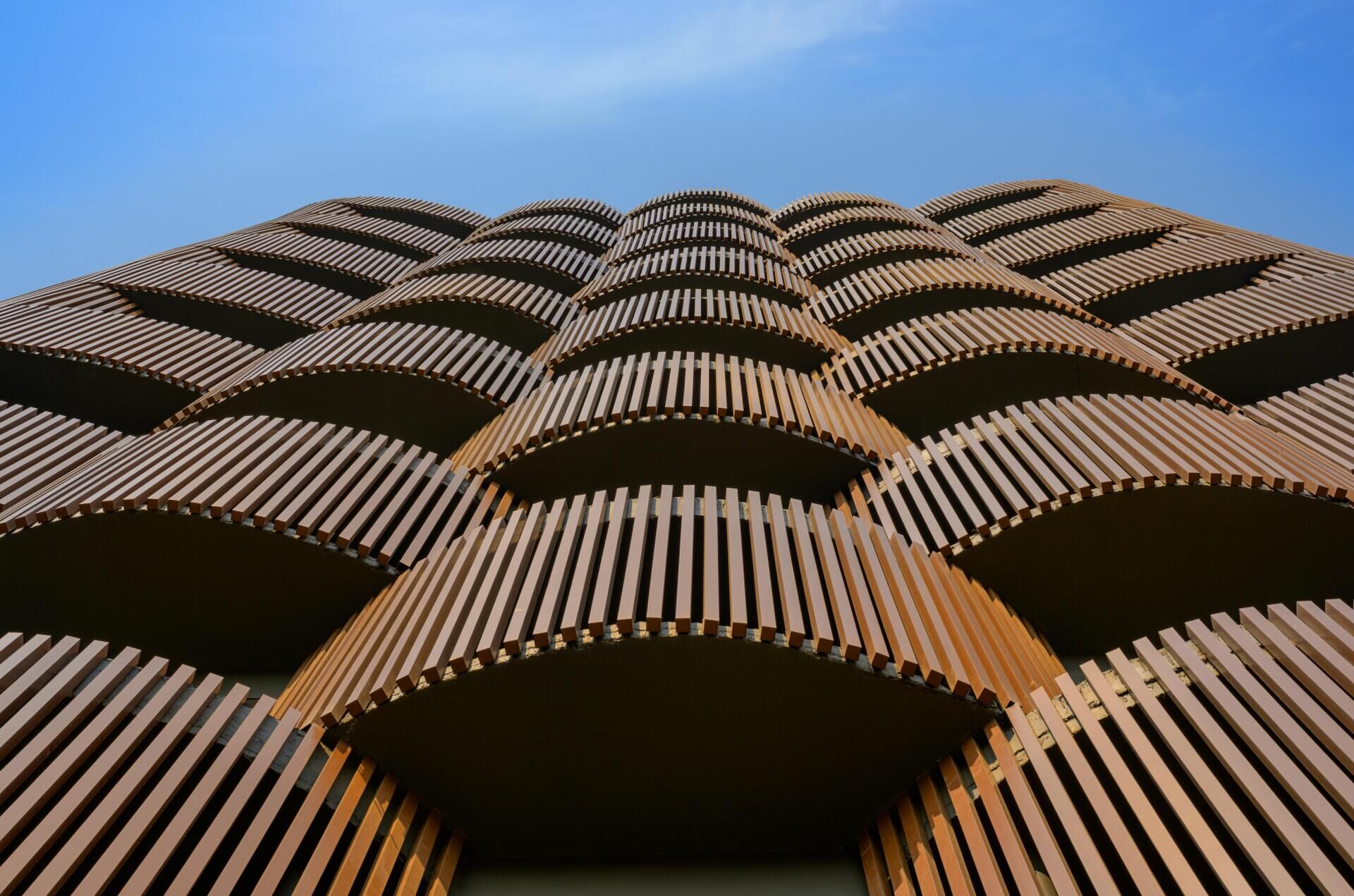 This 14-level office in Nagpur replaces the typical glass facade with layered decks, aluminum louvers, and greenery designed for 48°C summers. A climate-smart approach to modern workplace design.