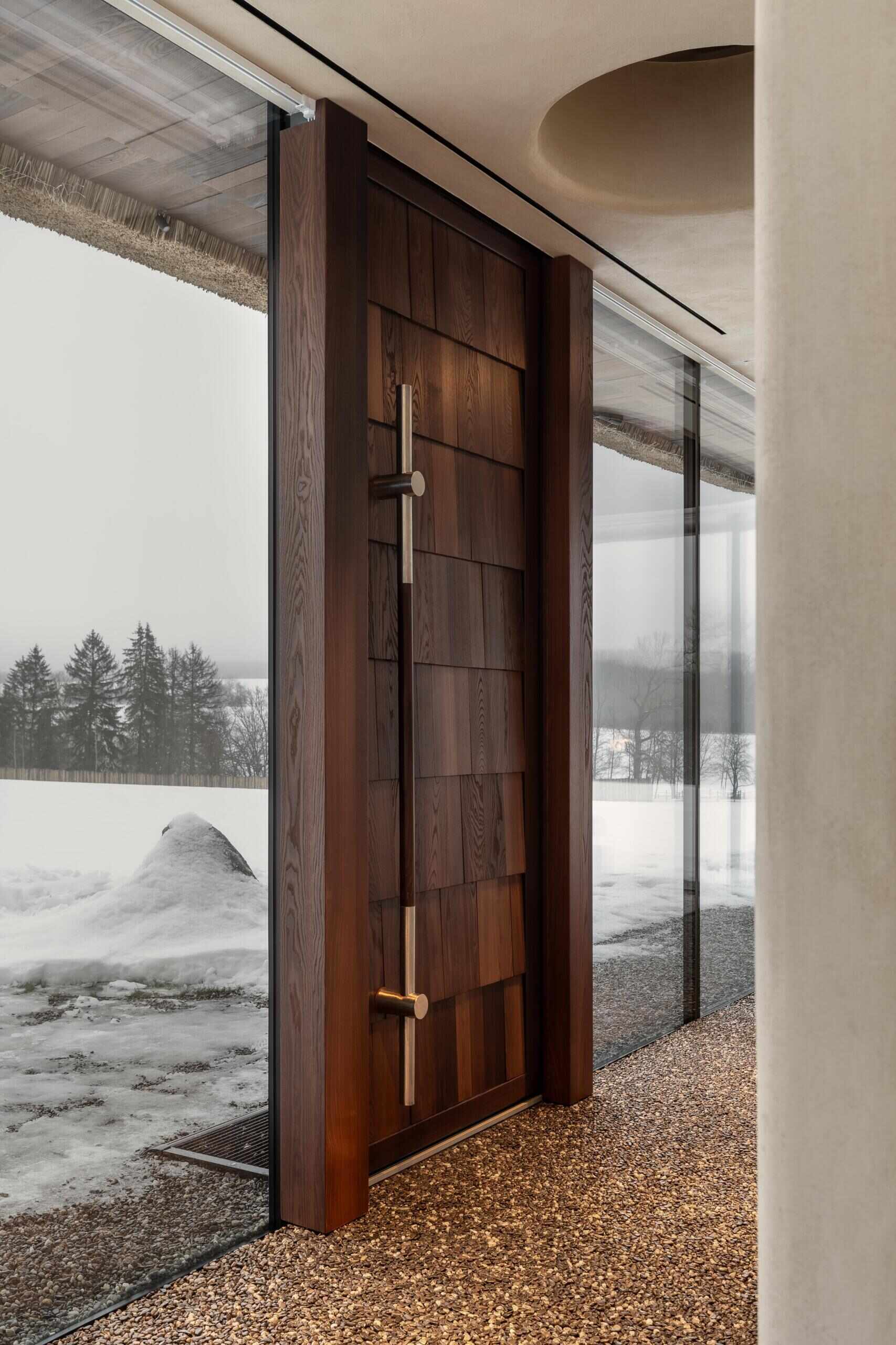 A wood door greets visitors, while a continuous stone carpet floor runs from inside to outside, designed to feel comfortable underfoot. Above, the roof dome rises to ten metres and is lined with wooden shingles, concealing all engineering systems and keeping the interior visually clean.