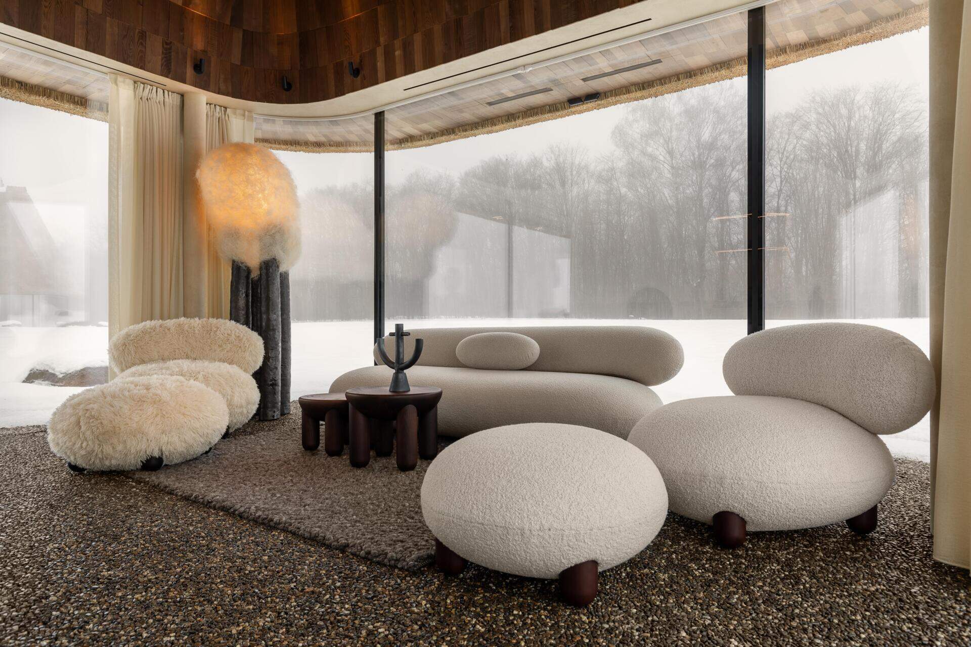 Inside, the living room sits on one side of a central concrete core. The space is deliberately simple, with a minimalist built-in fireplace as the main focal point.

There is no television. The idea is to replace screens with fire and views, encouraging guests to slow down and stay visually connected to what is happening outside.